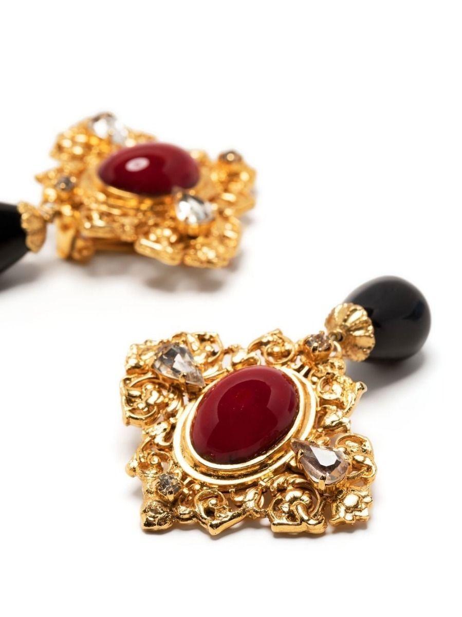 Designed by Gripoix in the style of Chanel, these unique vintage earrings display black glass beads hanging from an ornate gold-toned earring with large central red cabochons and rhinestones. A focal point of any outfit, these earrings can be