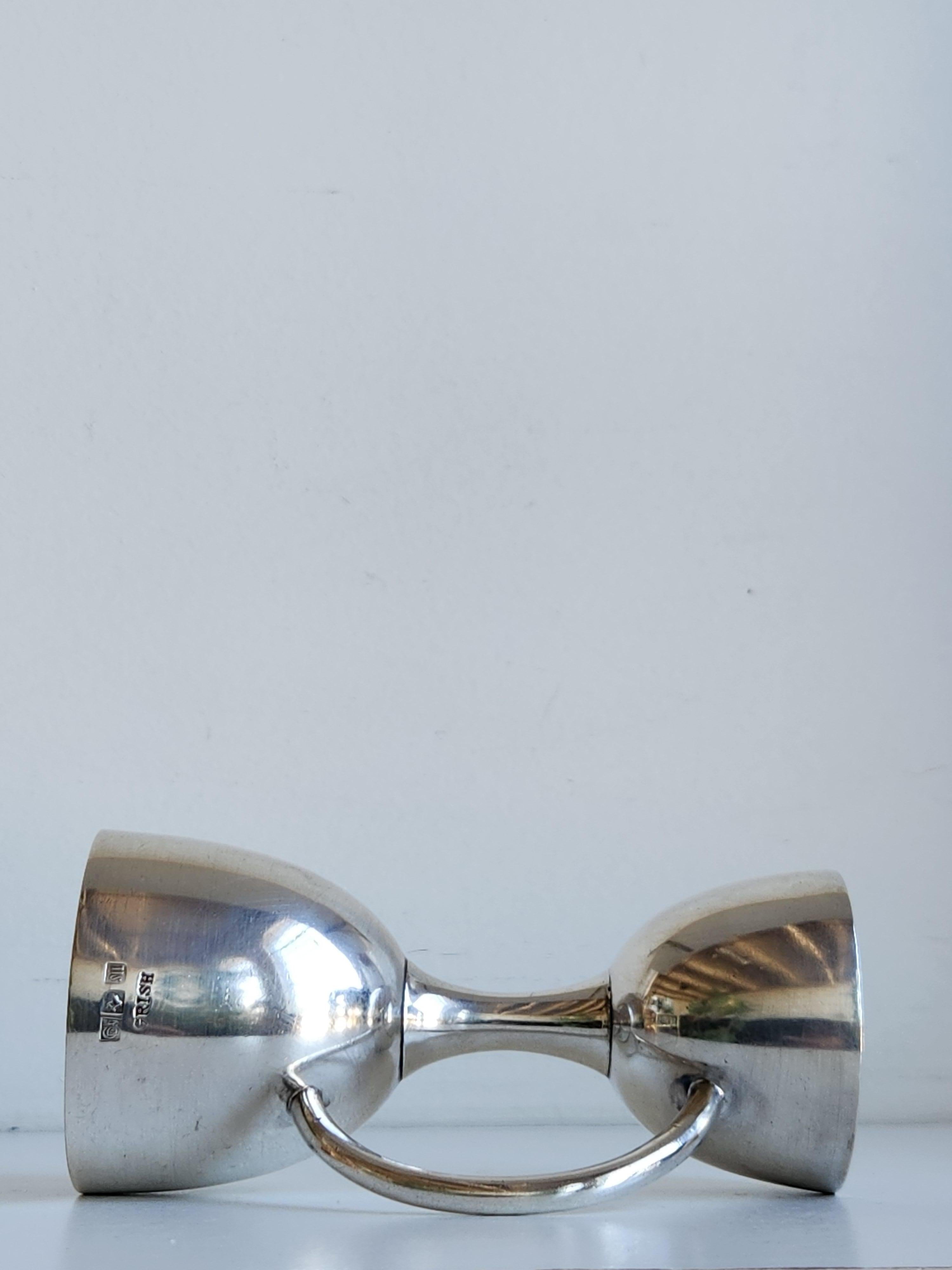 An Edwardian-style silver jigger by Grish Chunder Dutt. This double sided jigger is signed Grish and also has hallmarks for India and silver. This piece is in very good condition with only light wear typical for its age including a small dent near