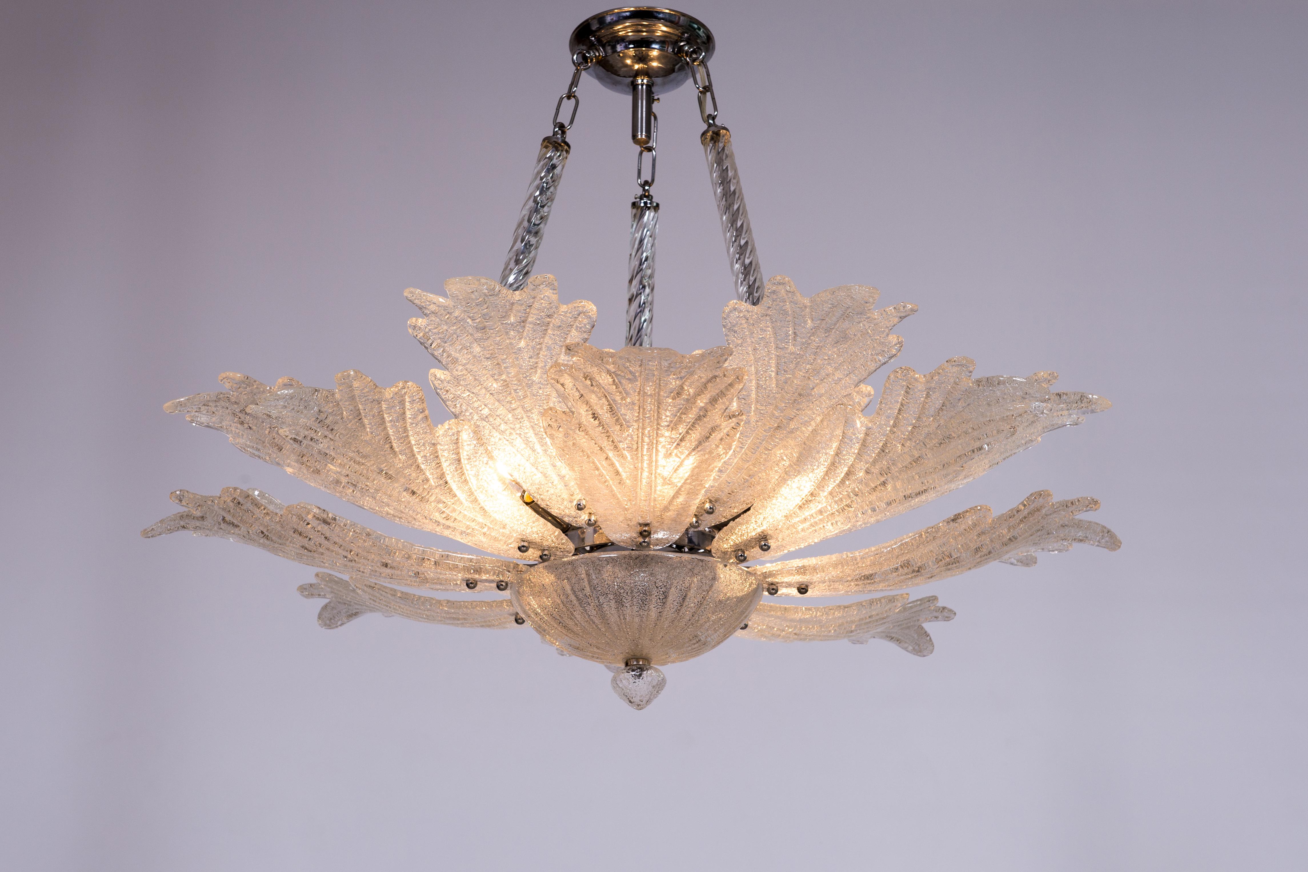 Grit Murano glass chandelier attributed to Toso 1970s Venice Italy.
The chandelier is sustained by a steel frame and three transparent twisted columns. Many designer glass leaves stretch out from the center and lean upwards; their slender shape
