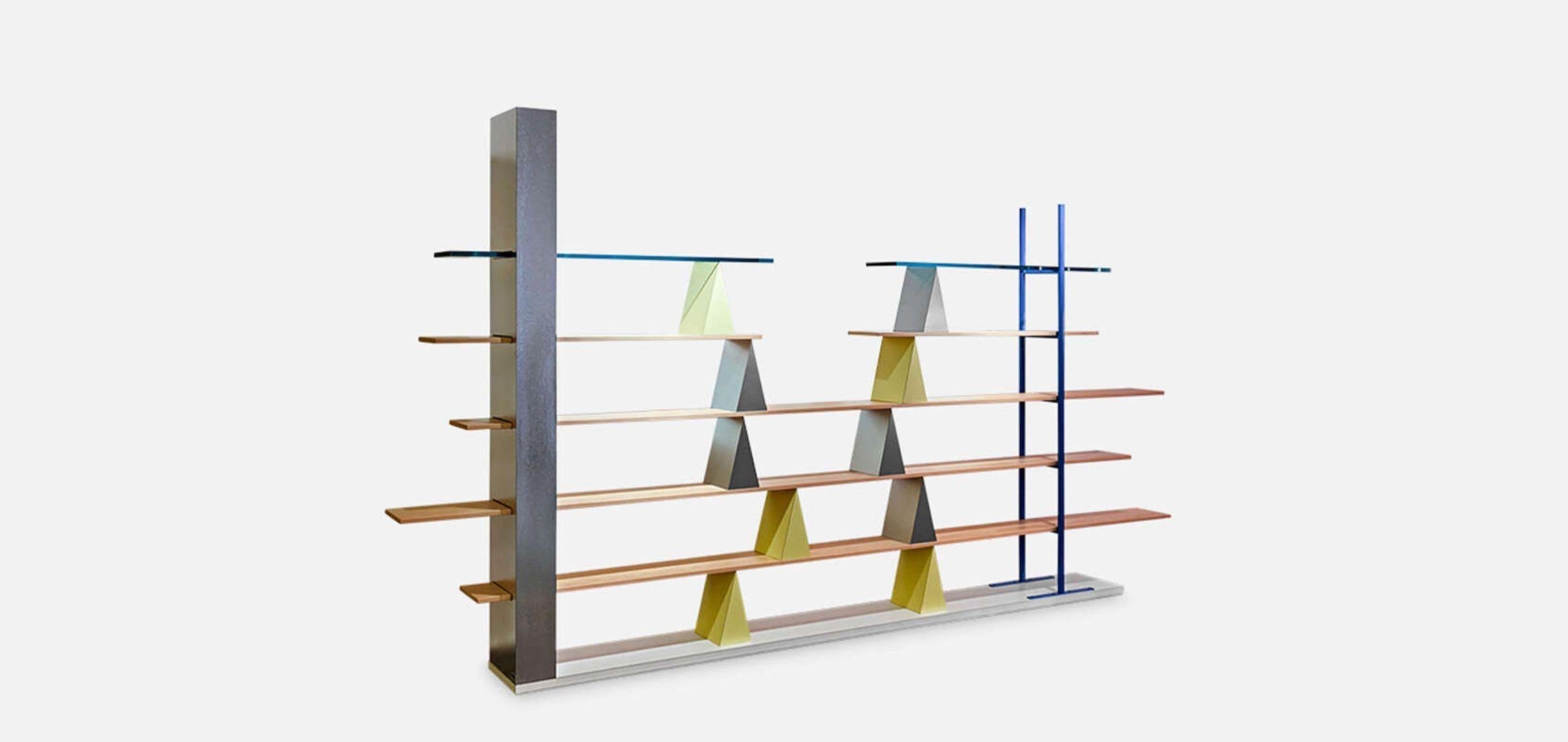 The shelves of Gritti seem to be interrupted at the center in a surreal way, and emerge in a disorderly way from the sides of the grid. The linear character of the apparently “normal” bookcase is broken up by the intersection of horizontal and