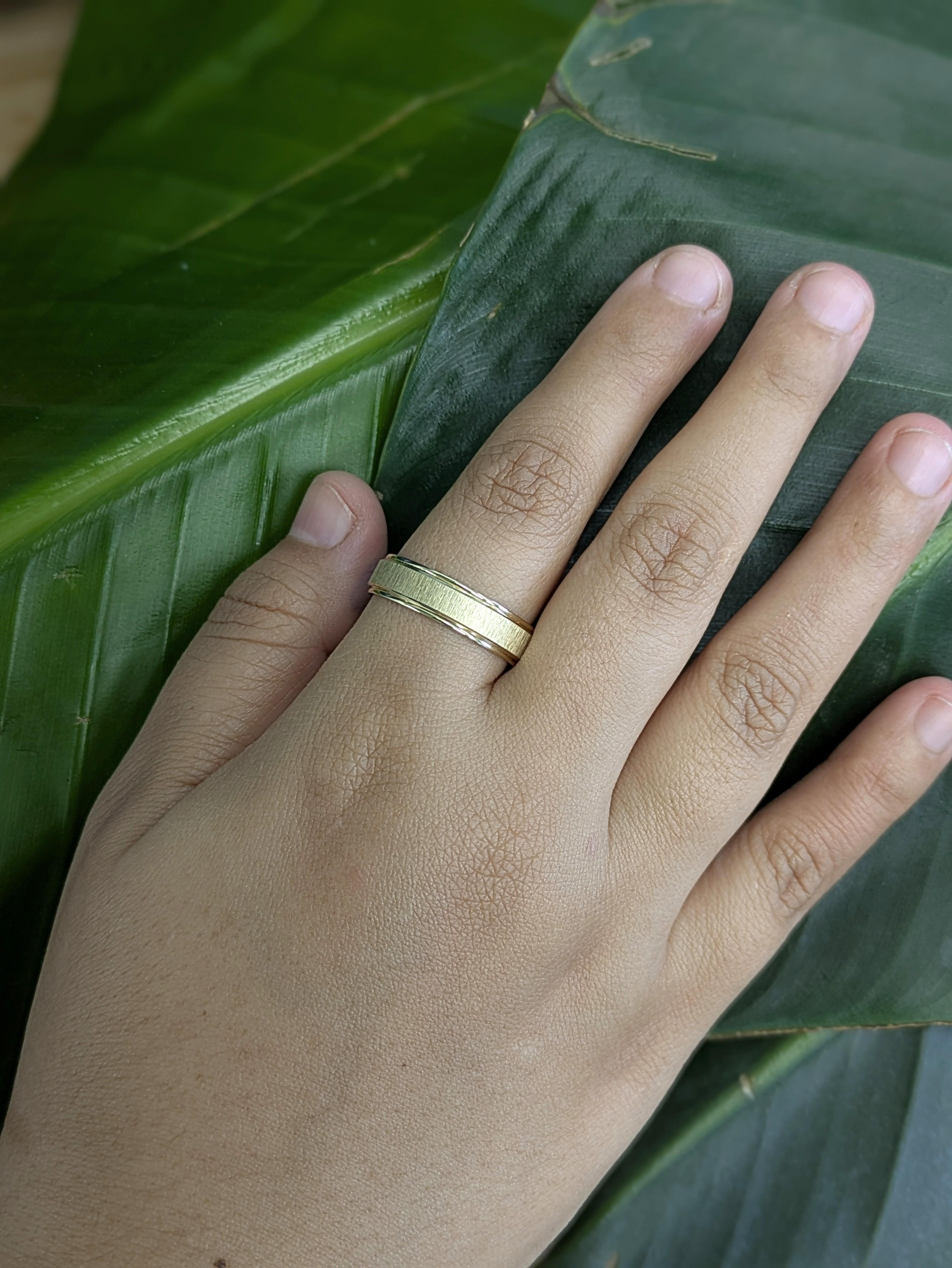 Una elegante banda de oro amarillo de 14k con una moderna ranura central para un estilo sutil y un carácter audaz. Diseñado para la comodidad diaria con un toque refinado y masculino.

Una banda de oro estriada de 6 mm que dice: 