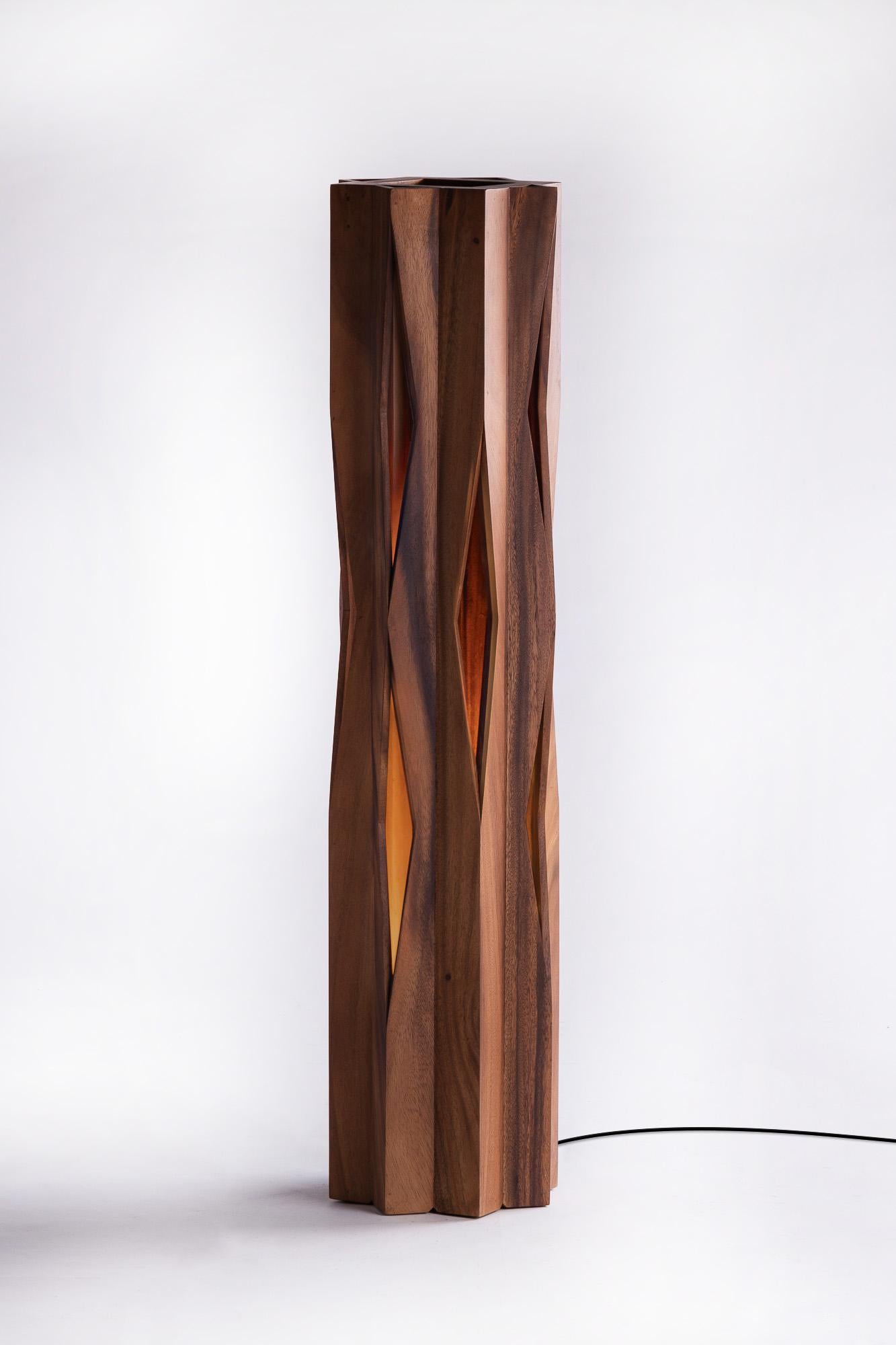Le lampadaire Groove présente des motifs intéressants sur des arêtes de bois qui sont simplement assemblées avec des angles inhabituels. Il en résulte des interstices de lumière qui font de la lampe une pièce captivante et apportent une touche
