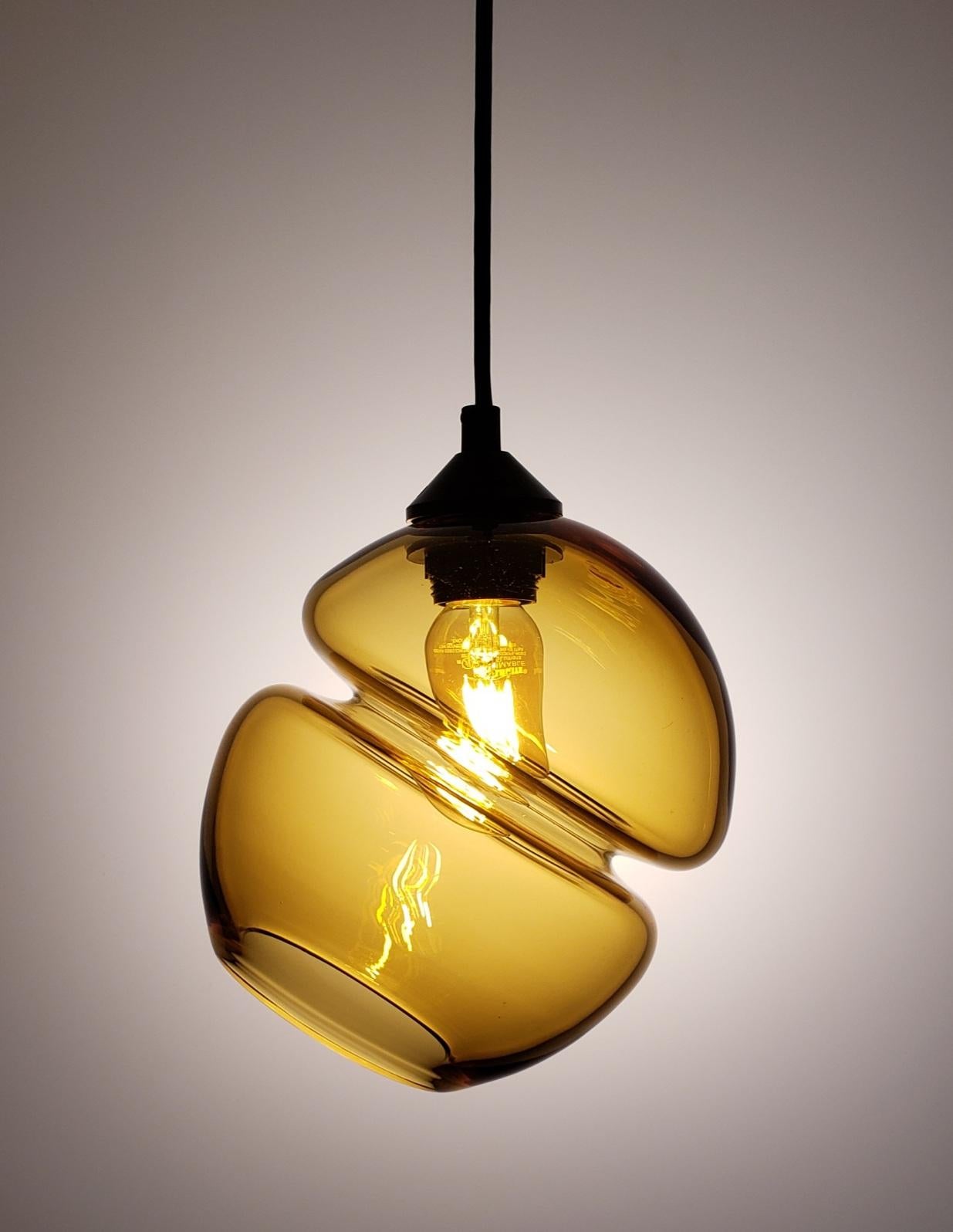 Ces lampes suspendues sont dotées d'une rainure intégrée qui confère à ces créations, par ailleurs entièrement réalisées à la main, une qualité de précision et de fabrication à la machine. Qu'ils soient présentés individuellement, en ensemble aligné