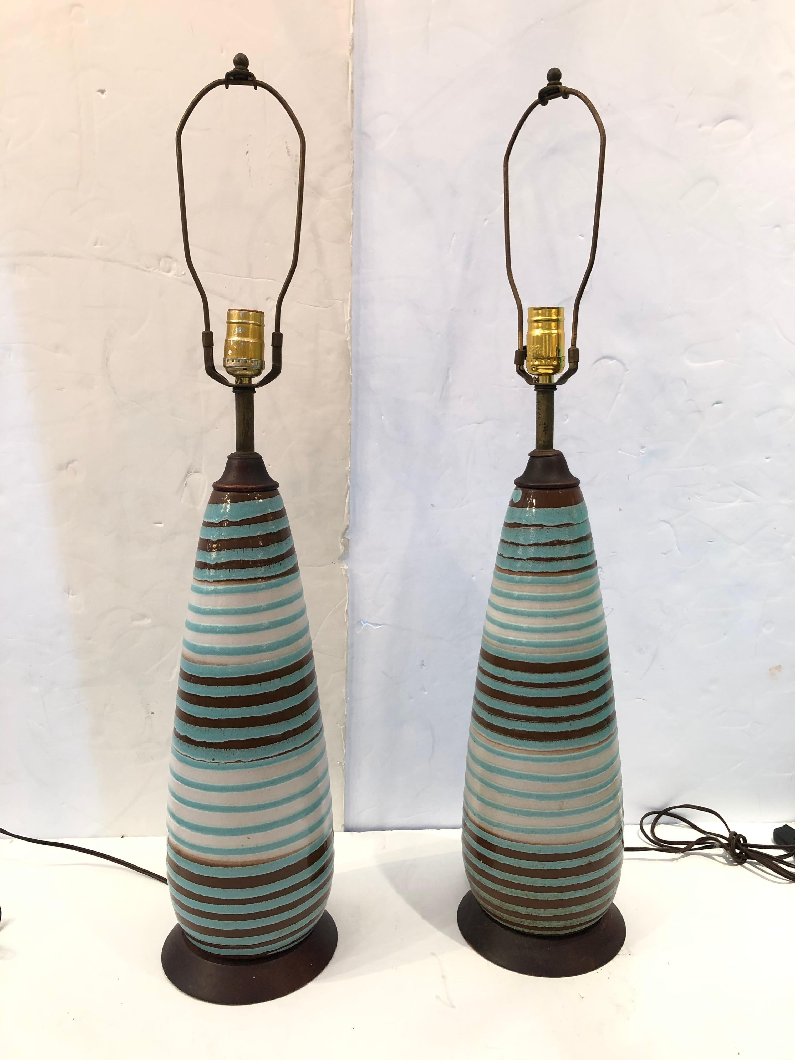 Groovy Mid-Century Modern rare pair of hand crafted glazed pottery table lamps having yummy color combo including cerulean blue, brown and cream, accented top and bottom by richly stained wood. Sensual elongated shape.
height to socket 24
No