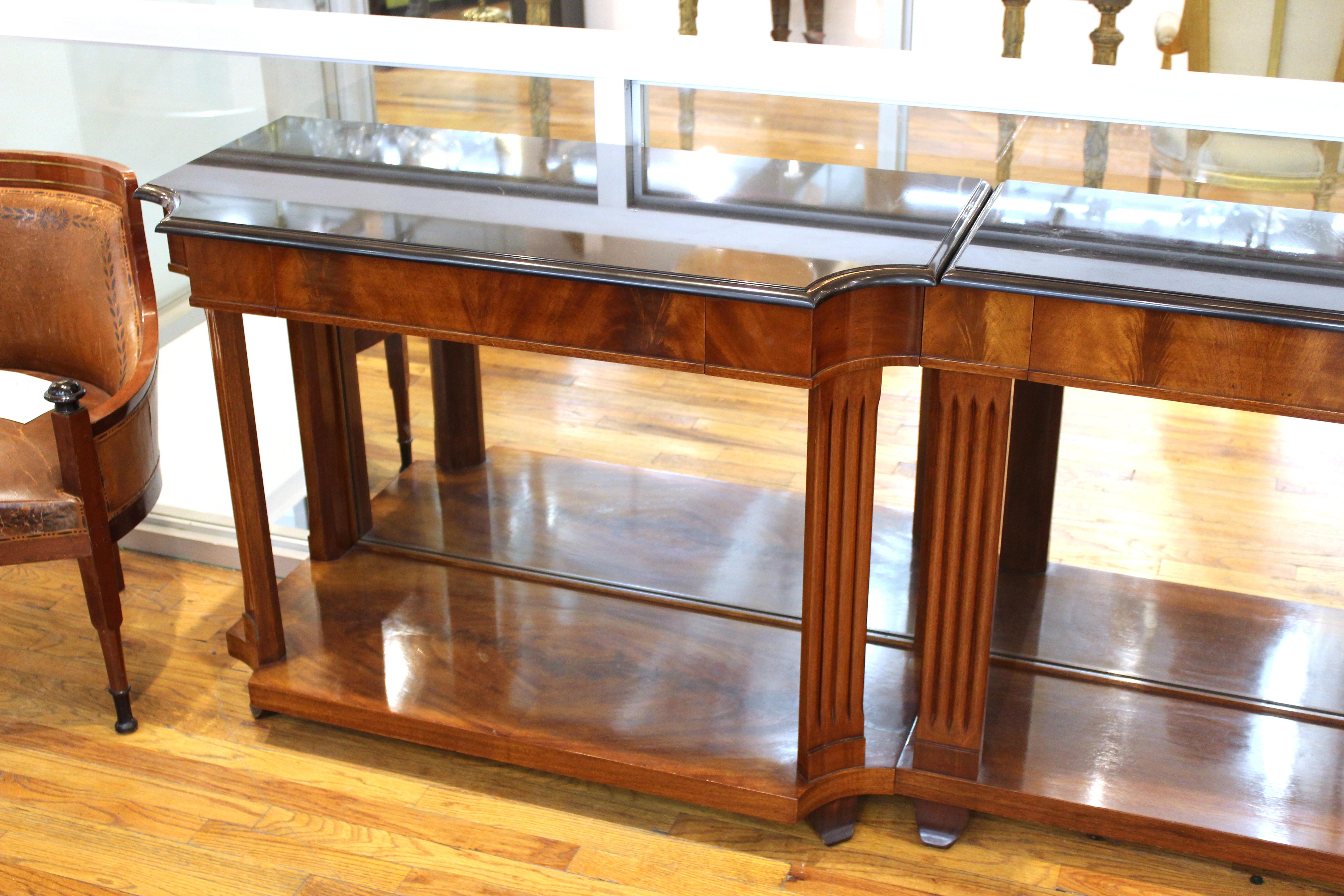 Grosfeld House Empire style flame mahogany mirrored console table in three segments, black marble tops over drawers and fluted legs. Measures: 33