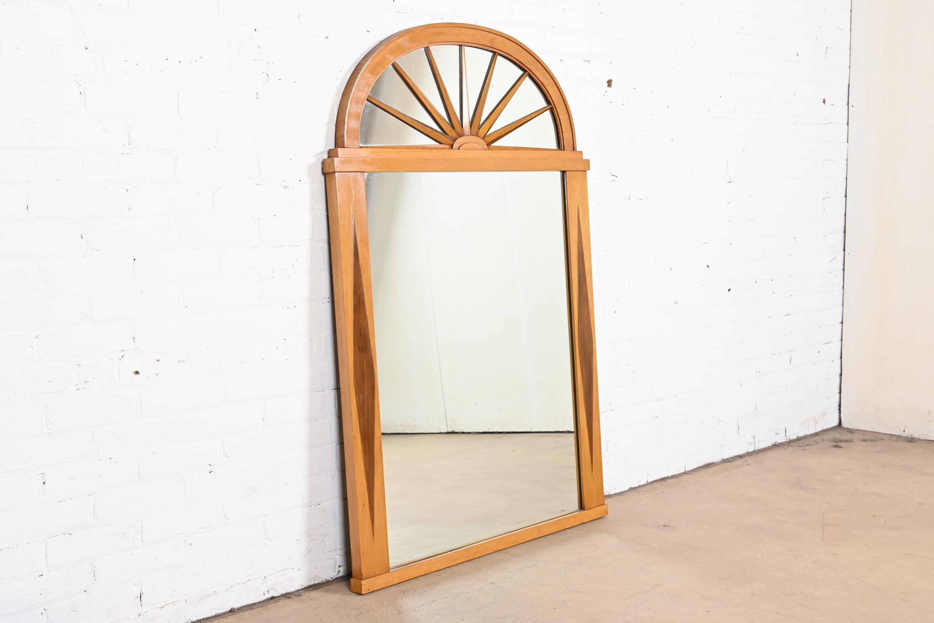 A gorgeous Hollywood Regency or Neoclassical wall mirror.

By Grosfeld House.

USA, circa 1940s.

Mahogany frame, with sunburst top and diamond inlay.

Measures: 36.5