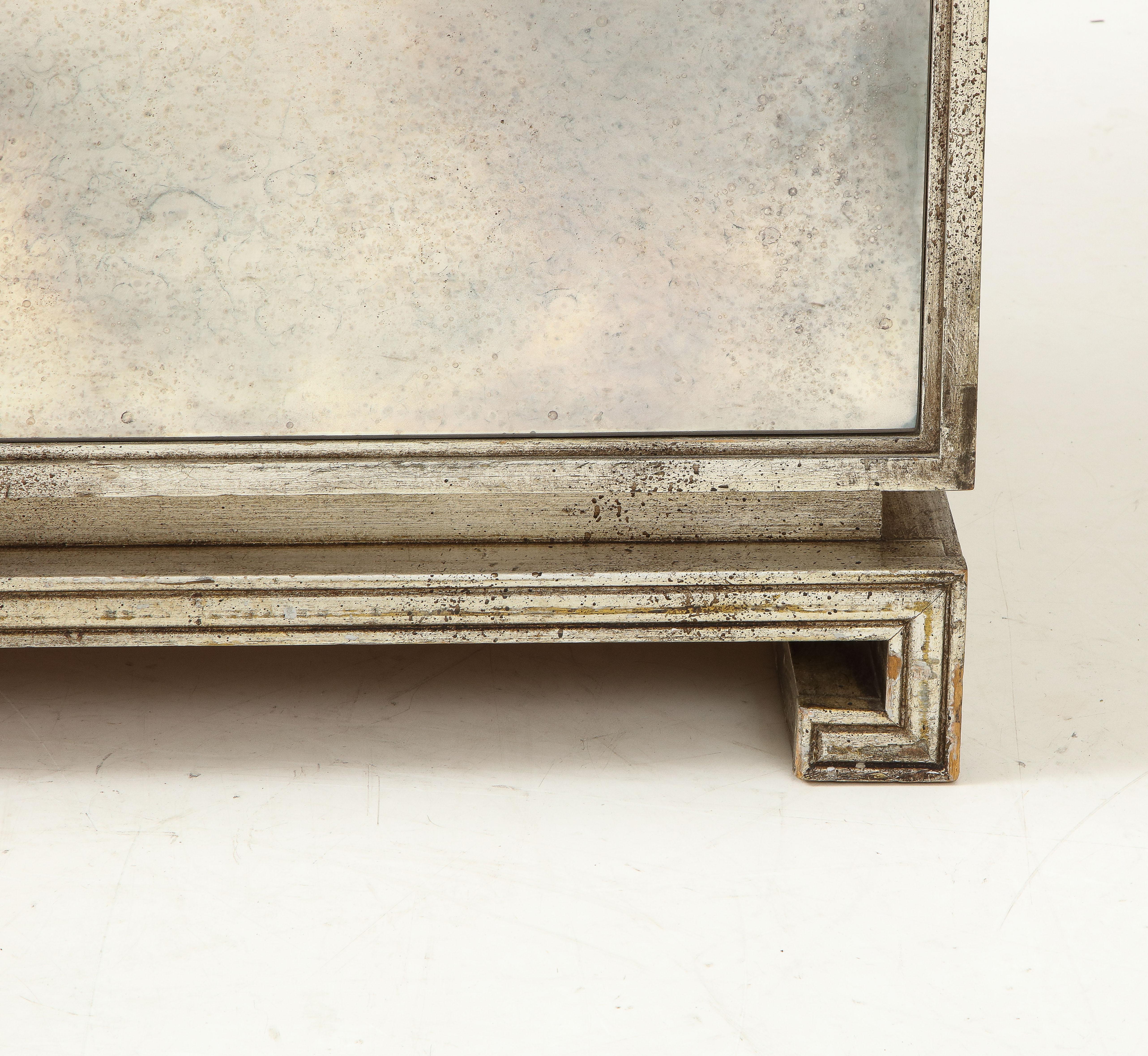 Verspiegeltes und versilbertes Sideboard von Grosfeld House, ca. 1940/50er Jahre, amerikanisch, zweitüriger Schrank mit antikem Spiegelglas und versilberten Holzverkleidungen, mit Lucite-Zylindergriffen, auf Sockel mit griechischem Schlüssel, der