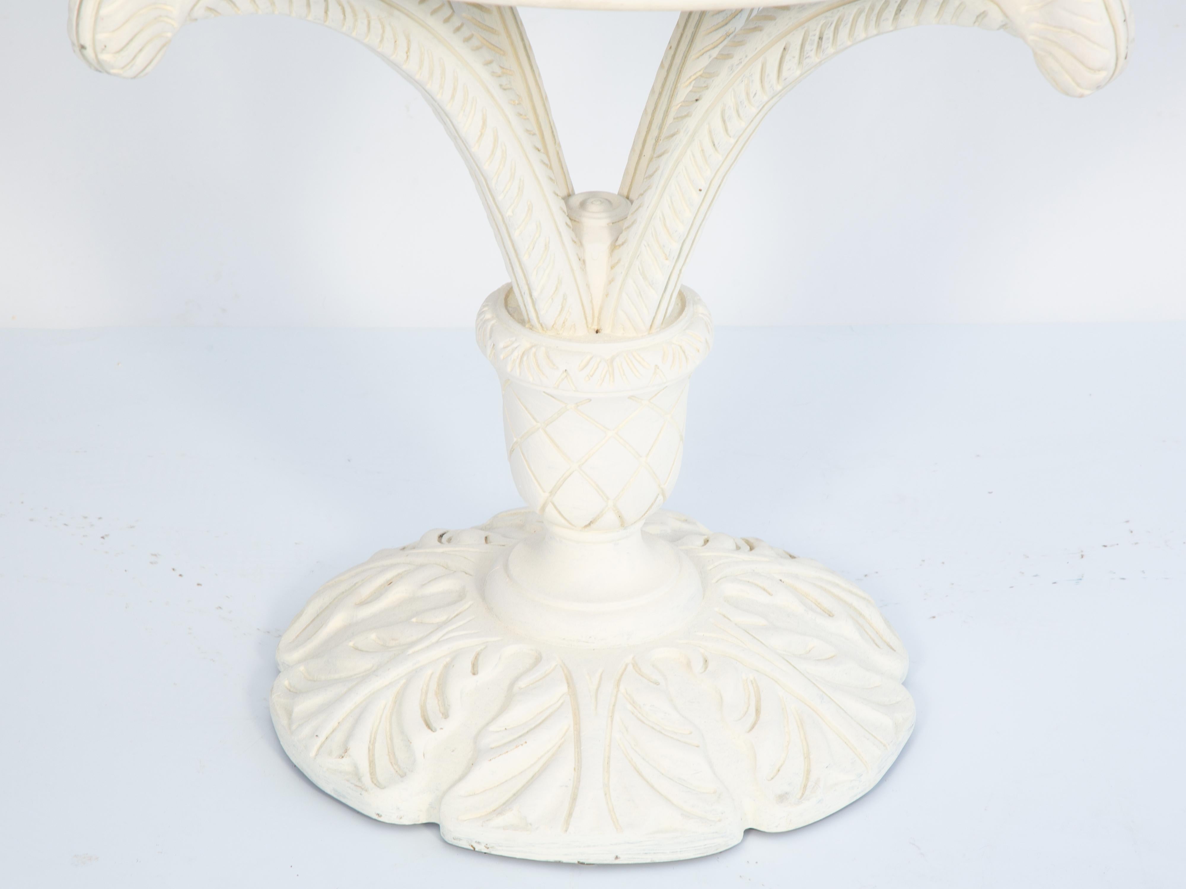 Vintage occasional table by Grosfeld House with ivory painted finish, having a shaped, rounded top with canted corners of Calcutta marble, in conforming border with channeled apron, raised on carved plume supports extending from a crosshatched urn,
