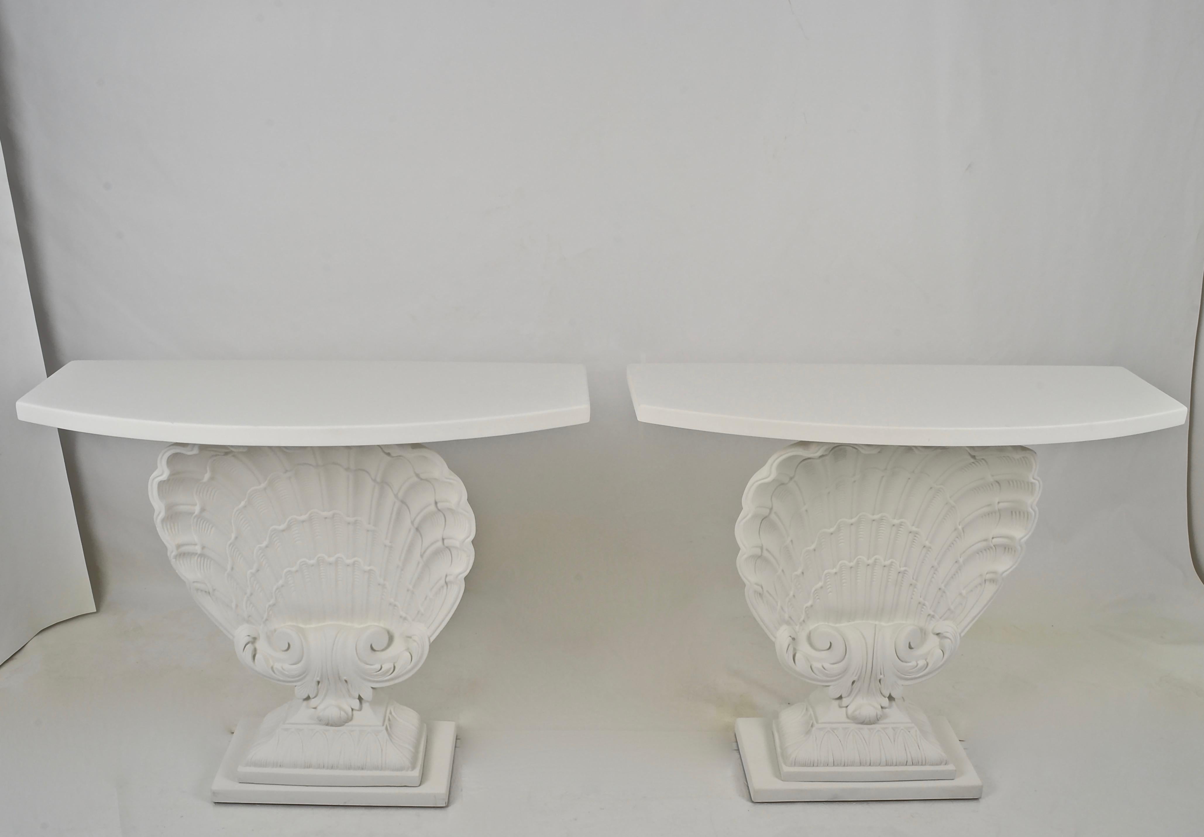 A beautifully restored pair of classic Hollywood Regency shell-form consoles by Grosfeld House. Newly painted in plaster white with a super flat finish. Excellent condition.