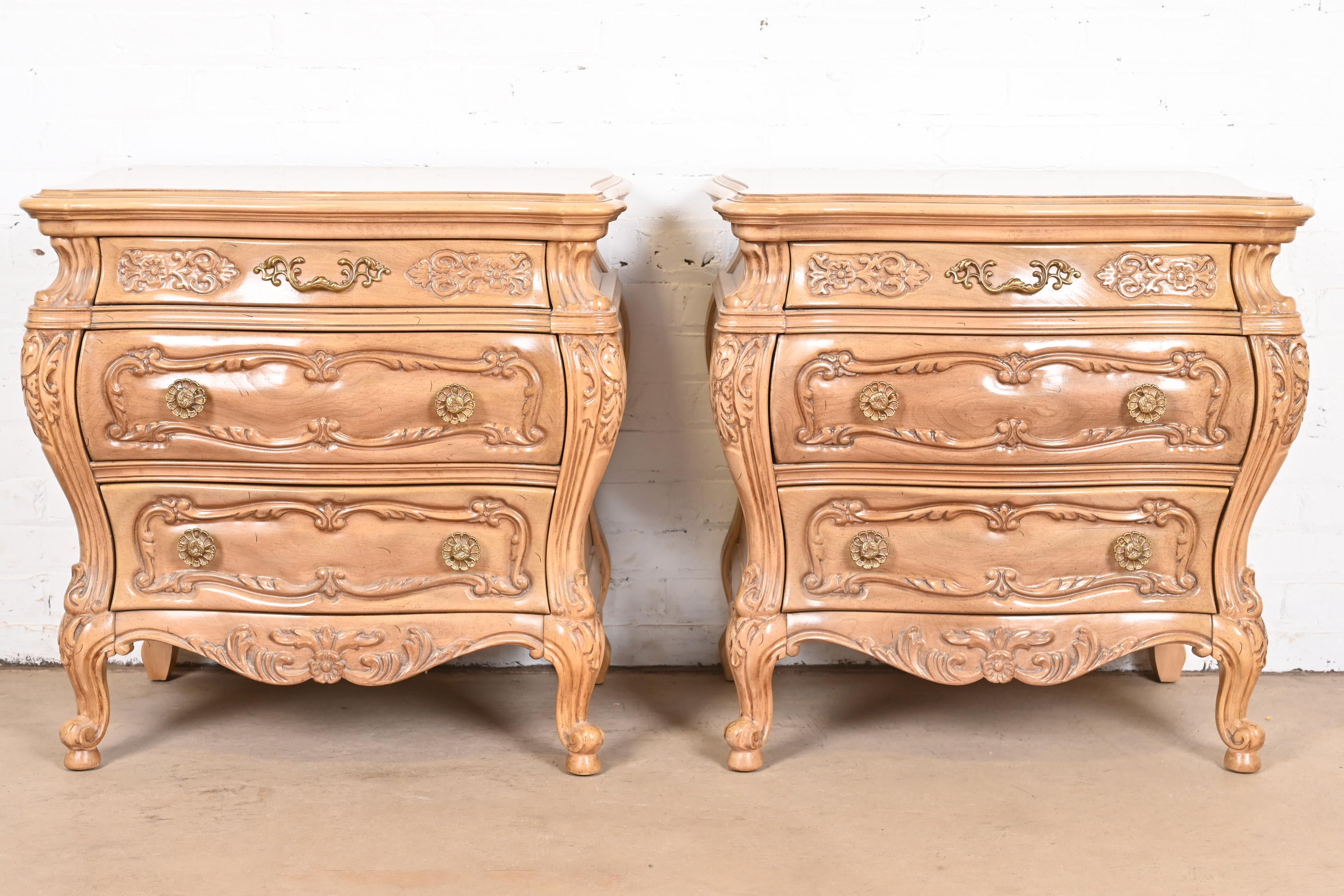 A beautiful pair of French Provincial Louis XV style bombay form nightstands, chests of drawers, or commodes

In the manner of Grosfeld House

USA, Circa 1960s

Carved bleached walnut, with original brass hardware.

Measures: 27.5