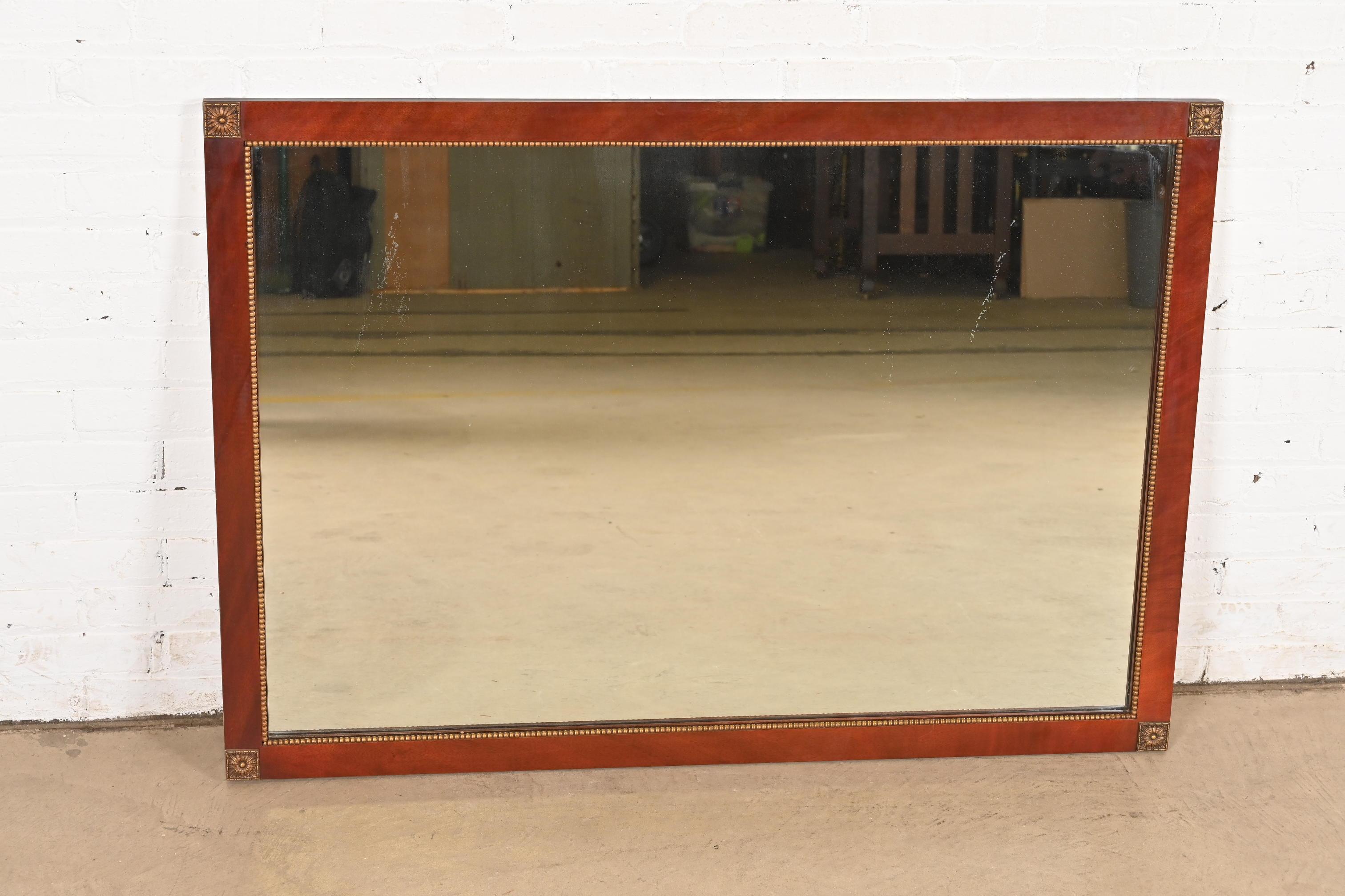 A gorgeous Regency or Federal style mahogany and giltwood framed large wall mirror

In the manner of Grosfeld House

USA, Circa 1940s

Measures: 47.5