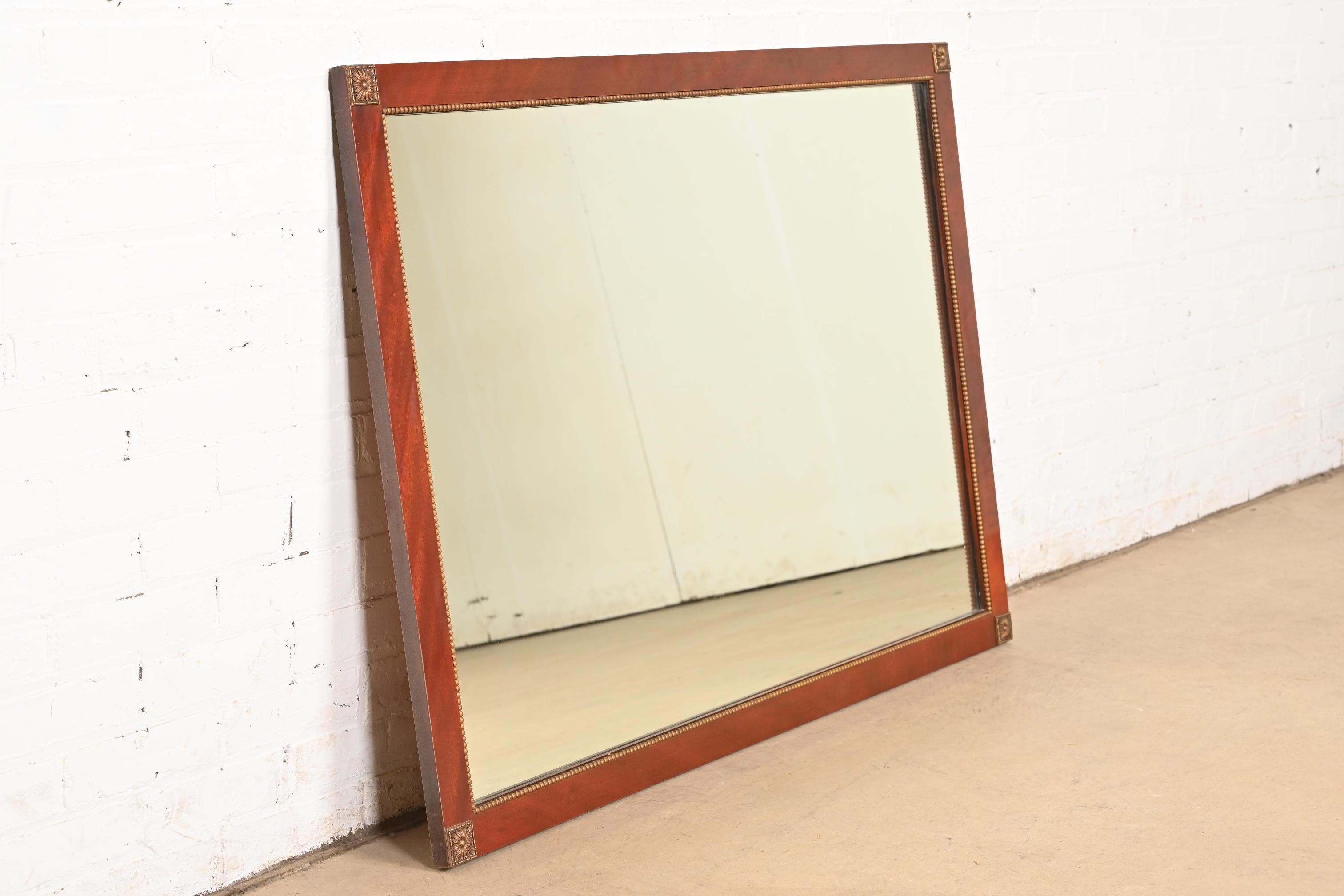 American Grosfeld House Style Regency Mahogany and Giltwood Framed Large Wall Mirror For Sale