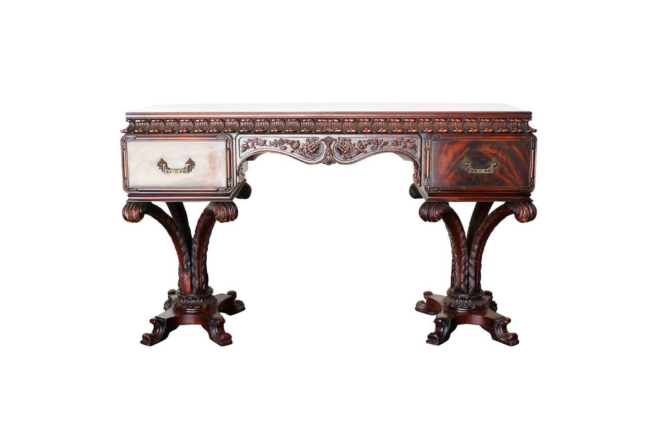 This desk features a beautiful hand carved top with two pullout drawers (one on each side) which sit on two carved wood plume palm tree bases much like the leg and table bases made famous by Grosfeld House's 