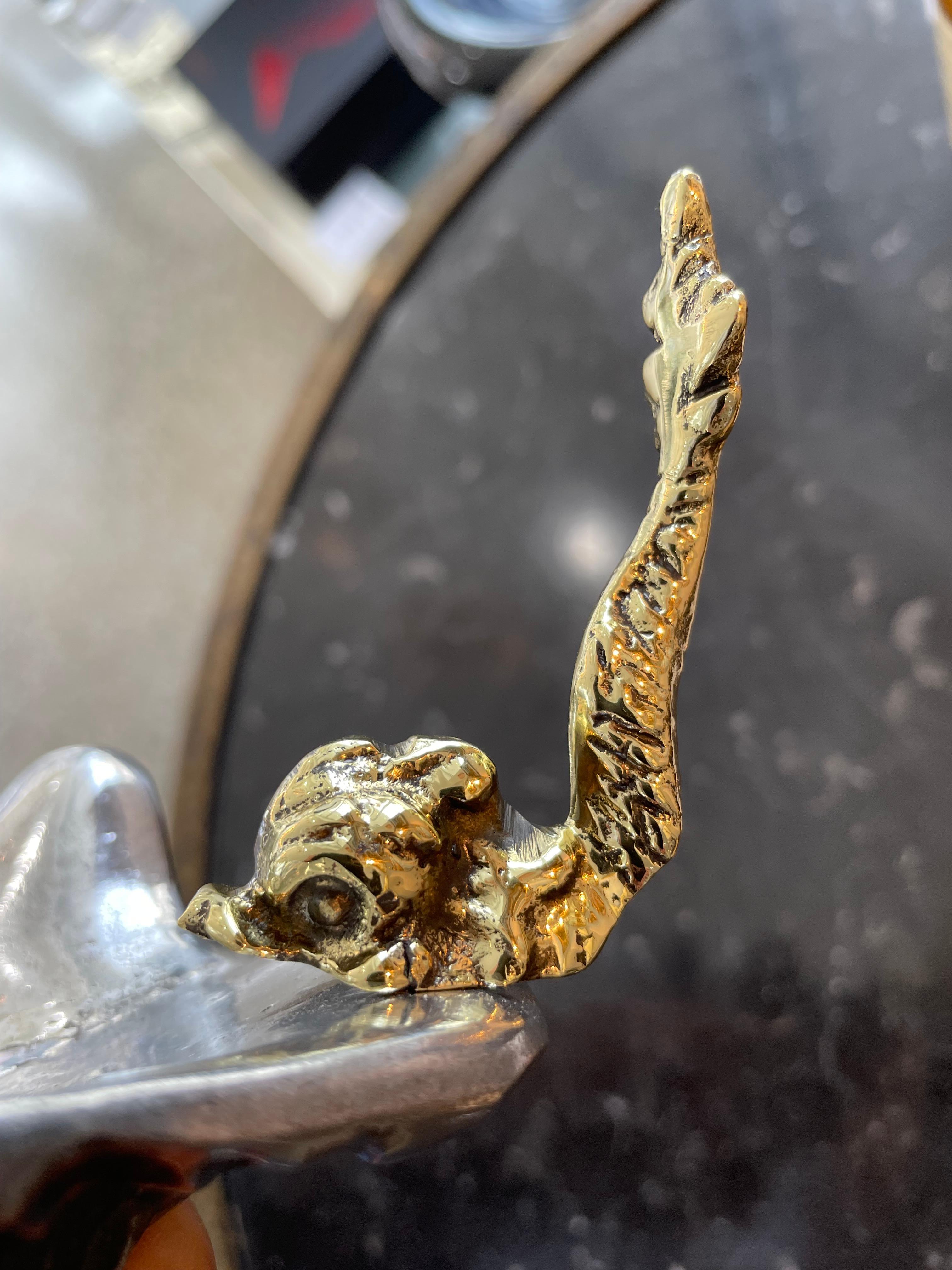 This stylish and chic Italian serving dish is very much in the Hollywood Regency style with its shell form bowl and sea serpent handle.   The piece is cast in aluminun and brass, and we have had the piece professionaly polished and the brass has a
