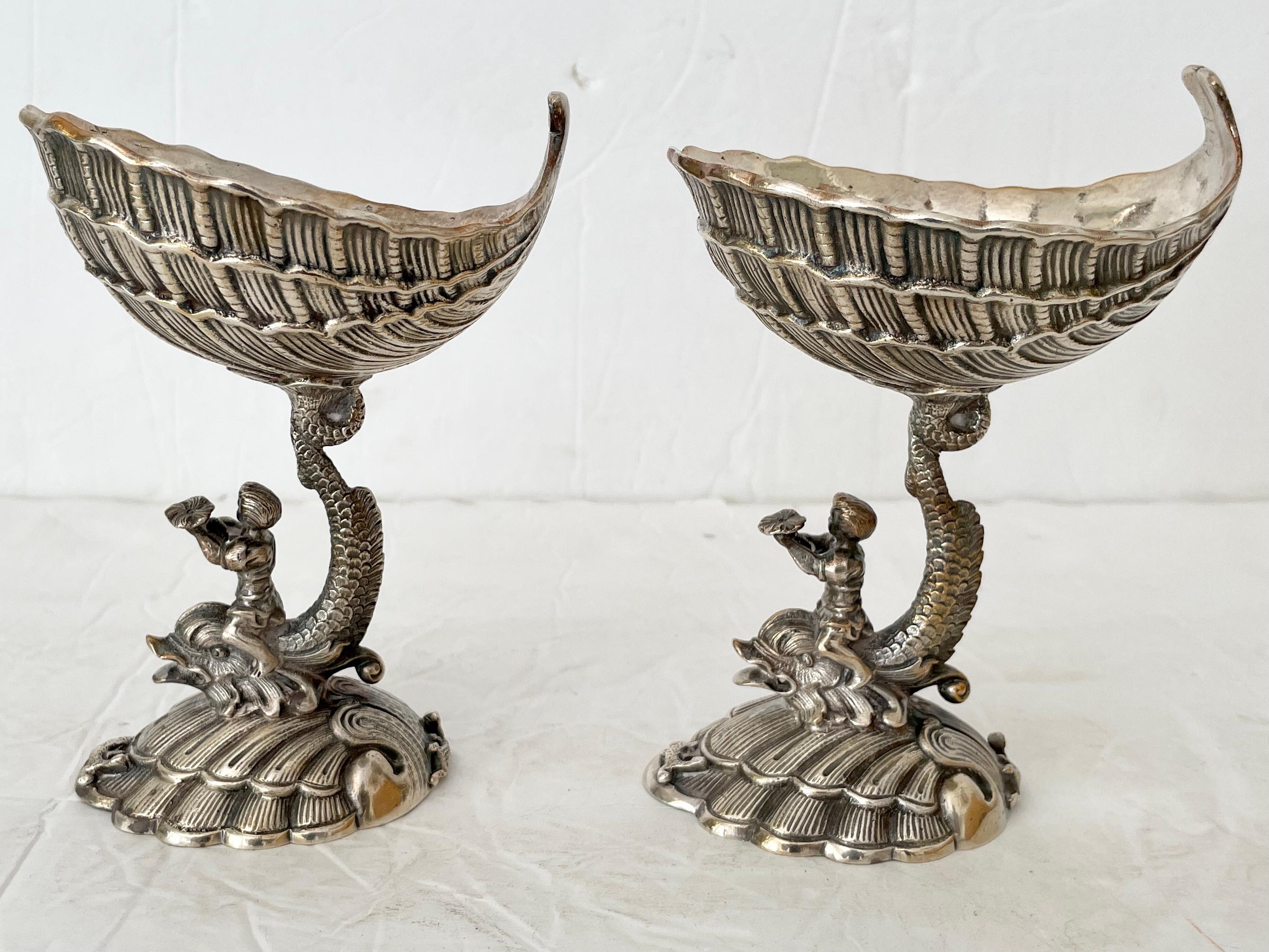 Beautiful pair of metal footed dish grotto style with men riding giant fish figurines. Great carving details.