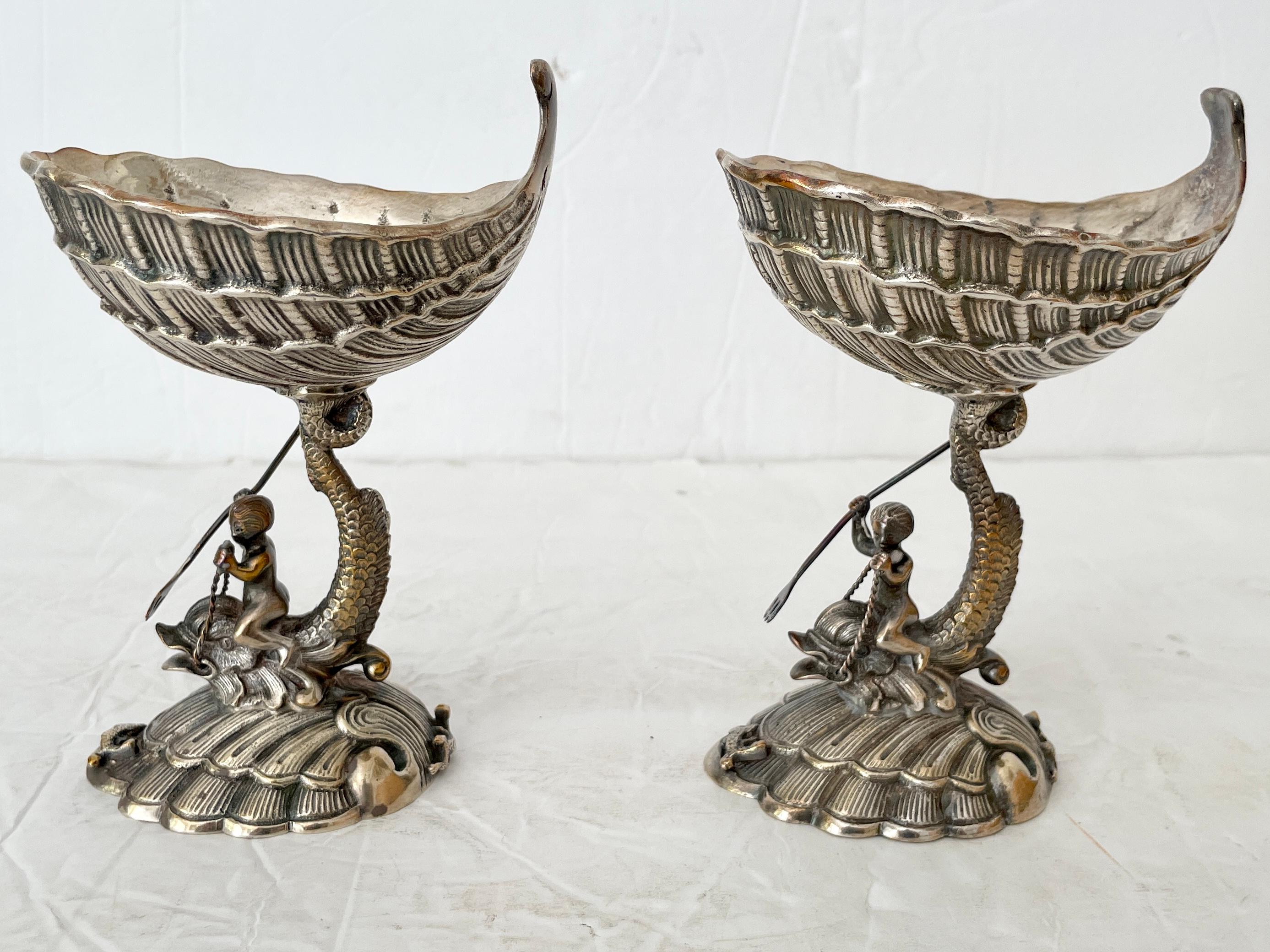 Beautiful pair of metal footed dish grotto style with men riding giant fish hunting figurines. Great carving details.