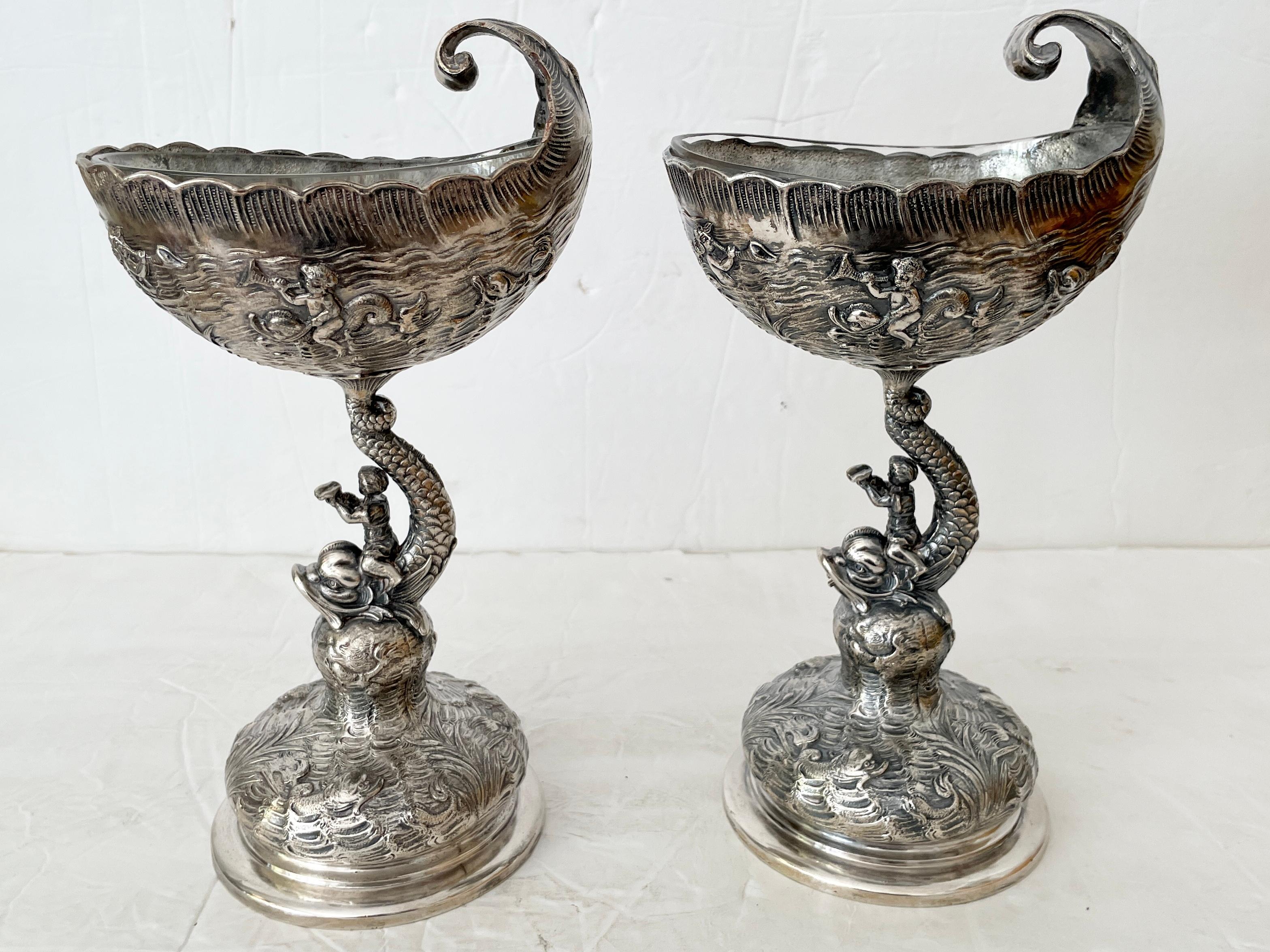 Beautiful pair of metal footed dish grotto style with men riding giant fish figurines. This pair includes a glass insert. Great carving details.