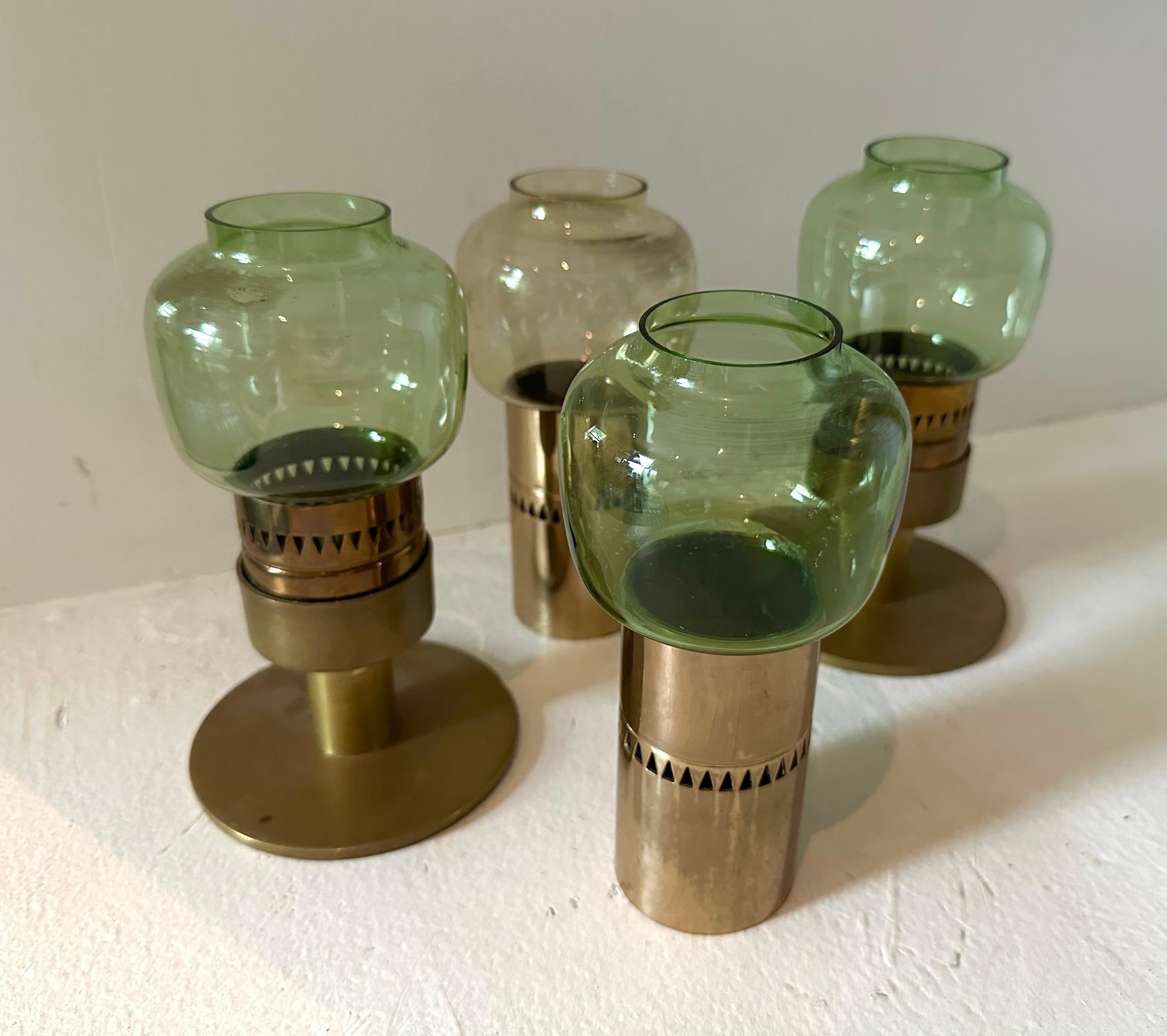 Cluster of four votive candlesticks with green tinted glass shades. Forms a little cityscape centerpiece or can be used individually. Etched signature to glass
