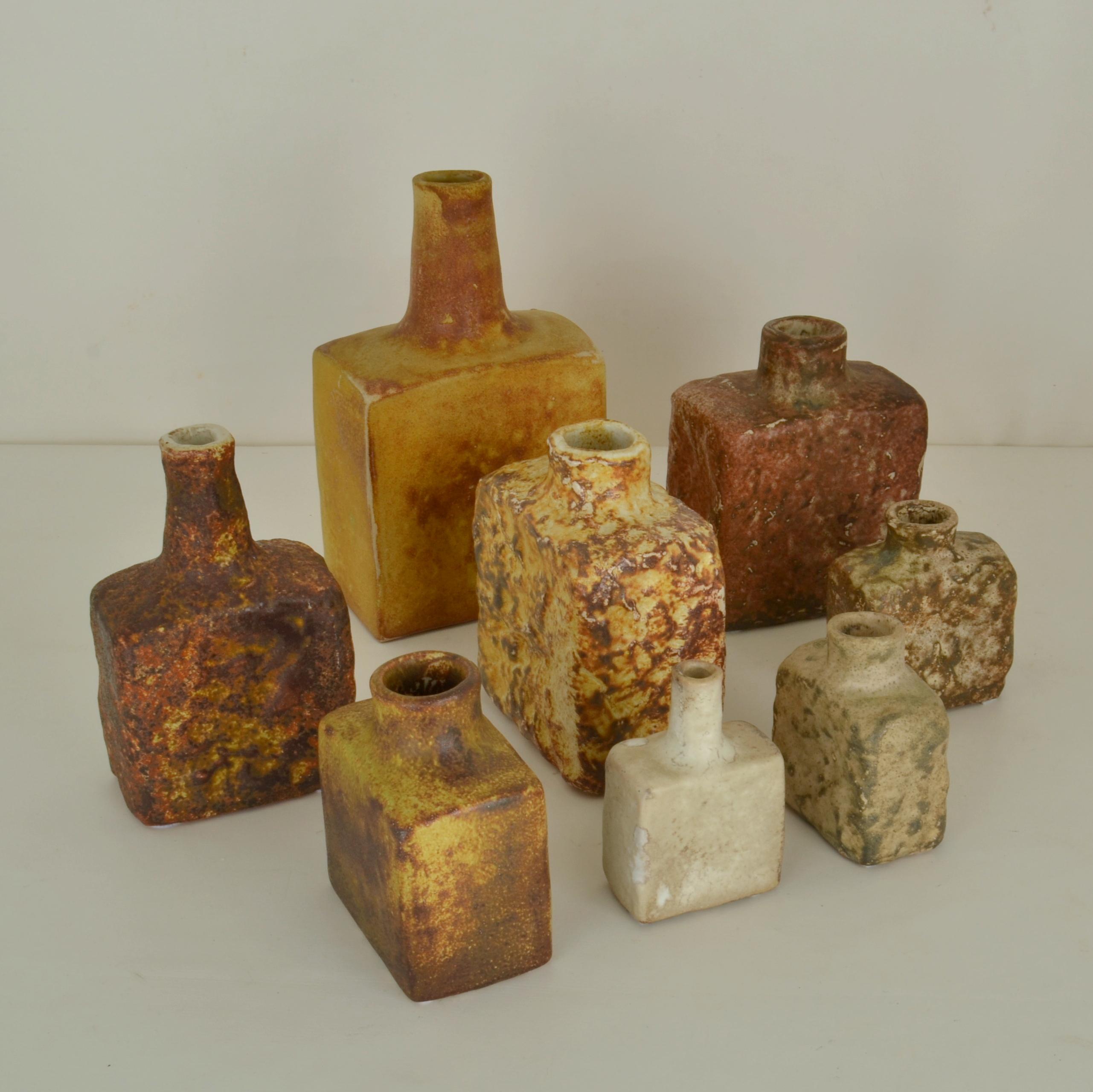 Set of eight Mid-Century Modern square studio pottery vases glazed in ocher and natural earth tones hand formed and in various heights by Mobach's Dutch ceramist made in the 1960's. The glazes made of natural resources are highly influenced by