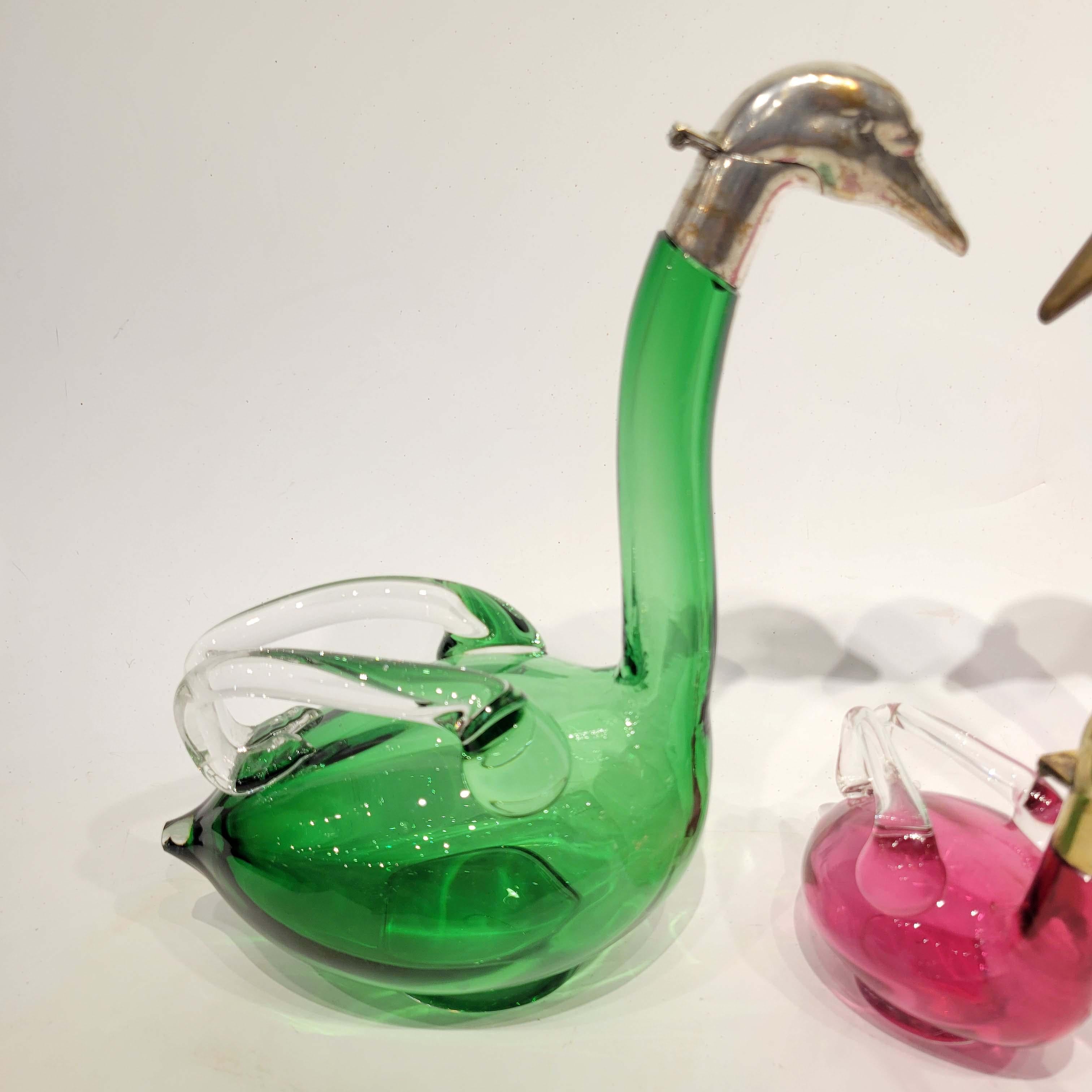 This is a wonderful group of 3 Austrian blown glass swan decanters. Stamped Austria on the bronze mount.
Each in good vintage condition. One with silverplated top, one with bronzed top and one in polished bronze top.
The larger decanter is 11.25