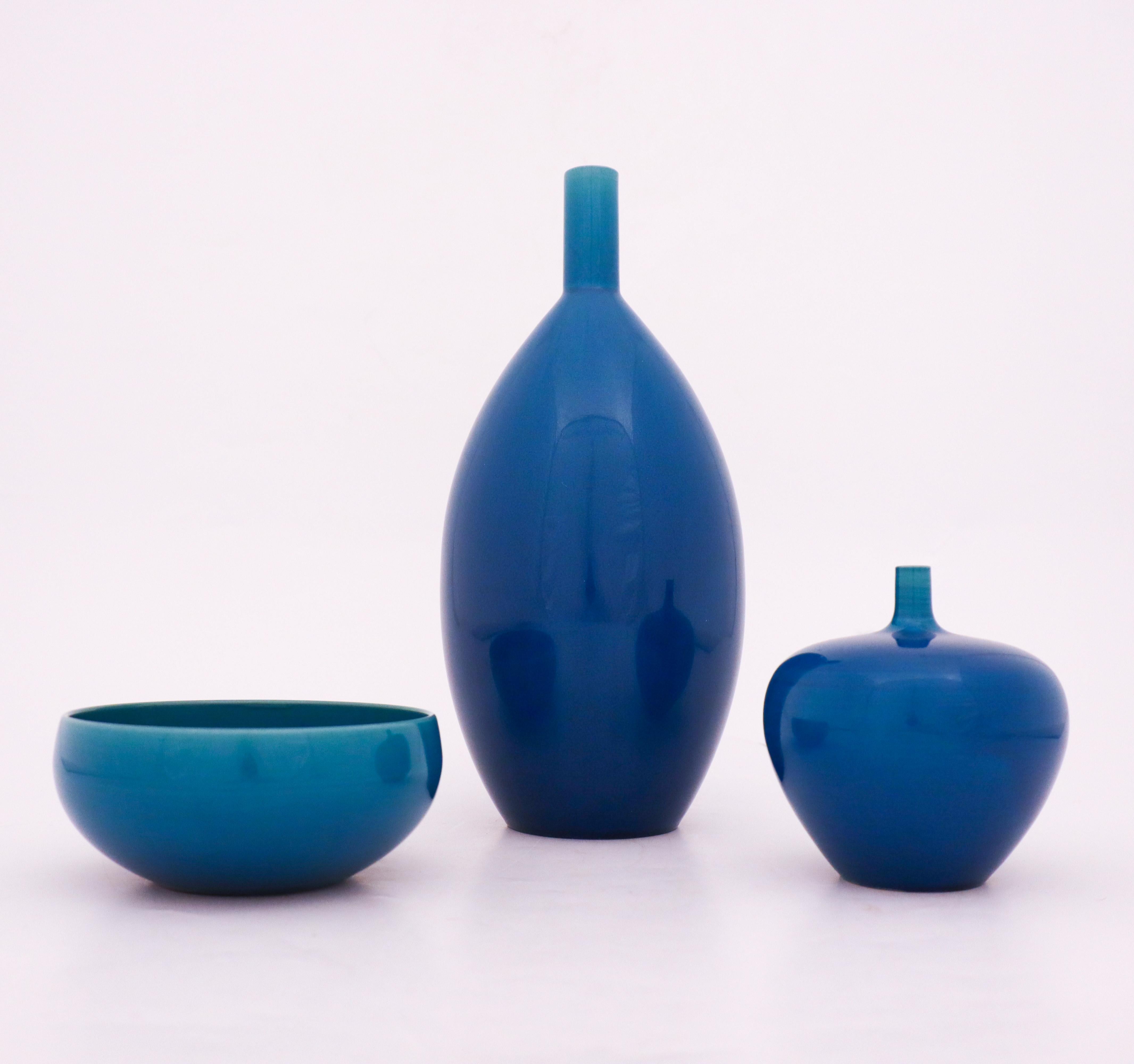 A group of two vases and one bowl designed by Carl-Harry Stålhane at Rörstrand in blue shiny glaze. The vases are 28 cm and 11 cm high and the bowl is 12,5 cm in diameter. They are in very good condition, the smallest vase has some scratching marks