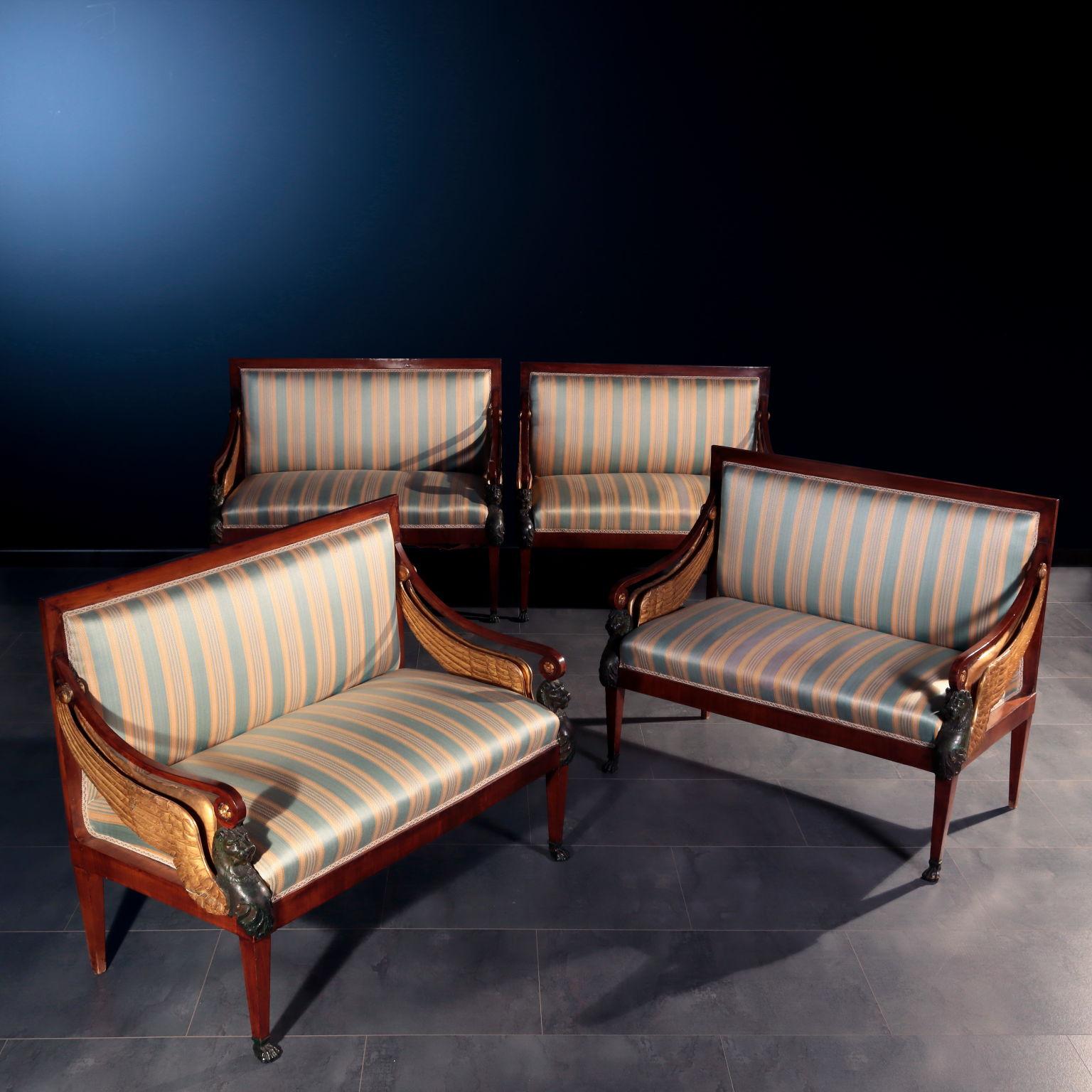Group of four settees supported by truncated pyramidal legs, the front ones have feet in the shape of feral paws. The uprights of the armrests are carved with the features of griffins, the lion bust is lacquered with an imitation burnishing, seeking
