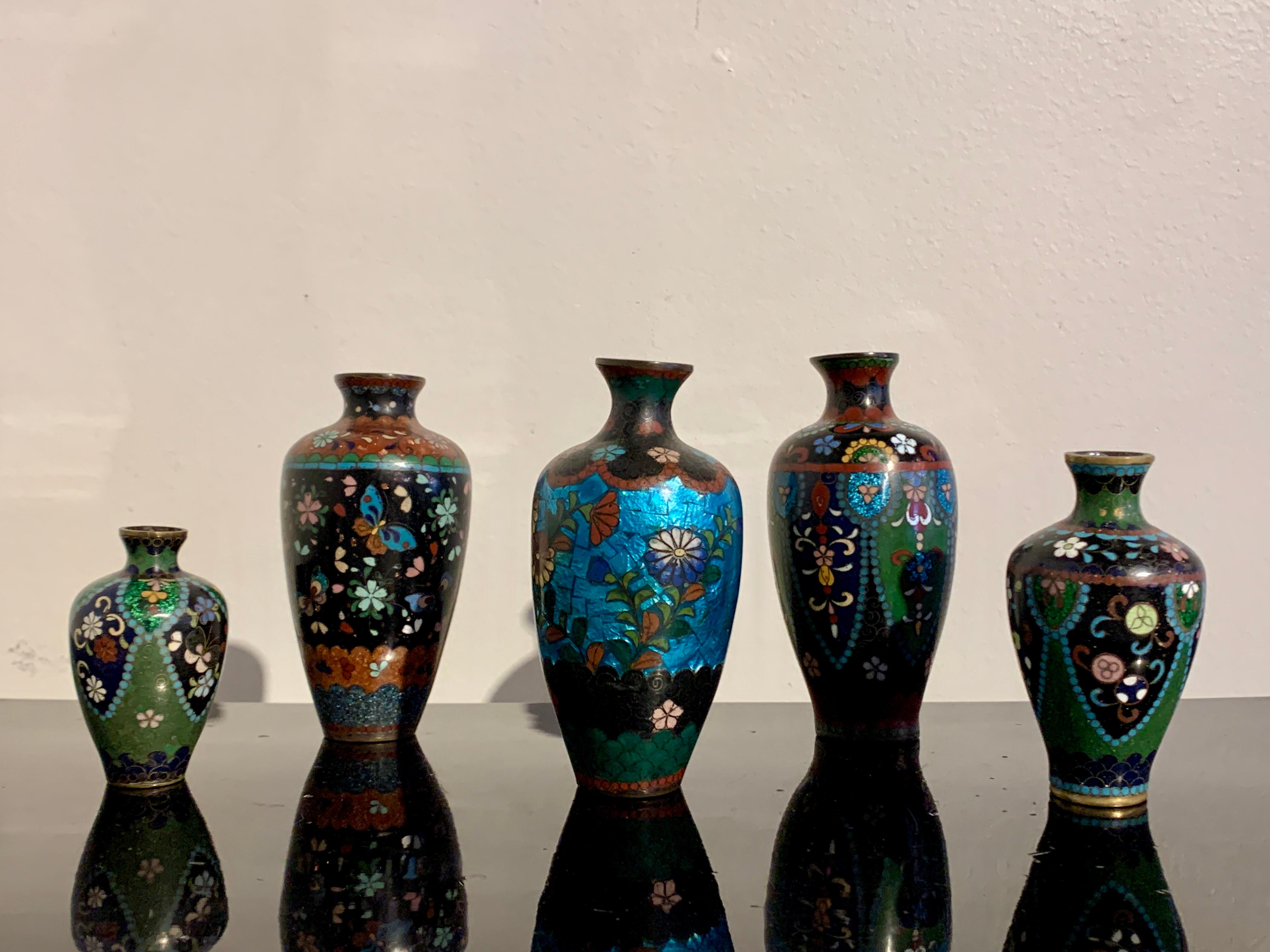 A charming group of five Japanese cloisonné and ginbari foiled vases, Meiji period, early 20th century, Japan.

The group consists of one vase with cloisonné chrysanthemum blossoms against bold and bright turquoise ginbari foil background, two