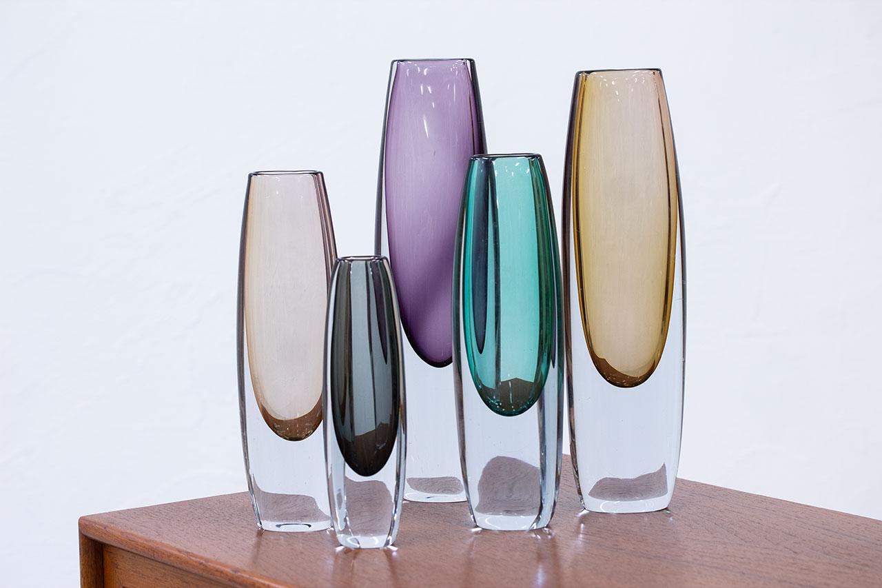 Group of 5 “sommerso” type vases. Designed by Gunnar Nylund and Asta Strömberg. Manufactured by Strömbergshyttan in Sweden during the 1950s. Colored glass cased in clear glass technique. Three of the vases are signed (engraved on the bottom).
The