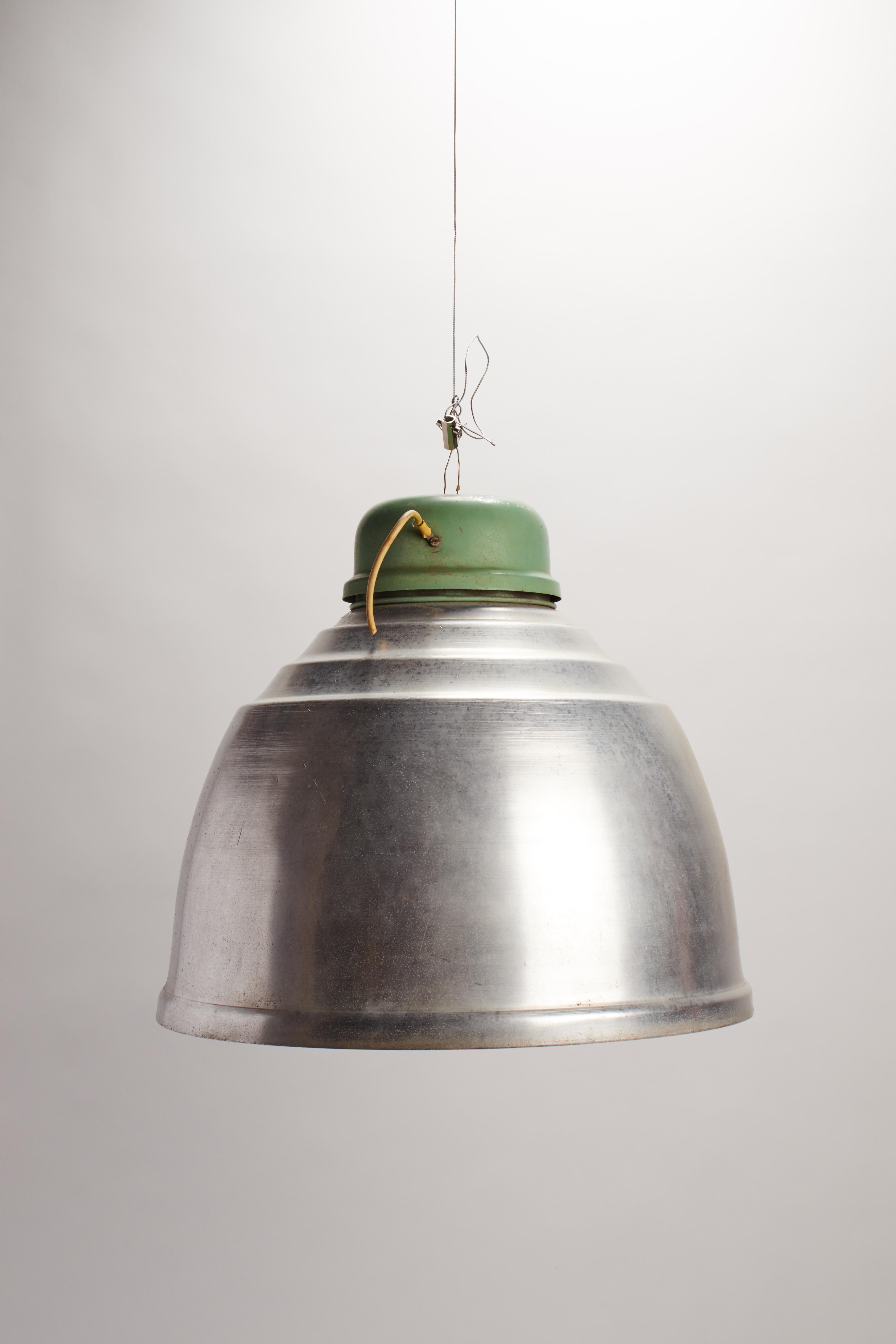 Eine Gruppe von schwingenden Industrielampen, grüne Emaille über Aluminiumkuppel. Eisenhaken zum Aufhängen, Porzellanrad, Metalldraht. Auch separat erhältlich. Italien 1920 ca.