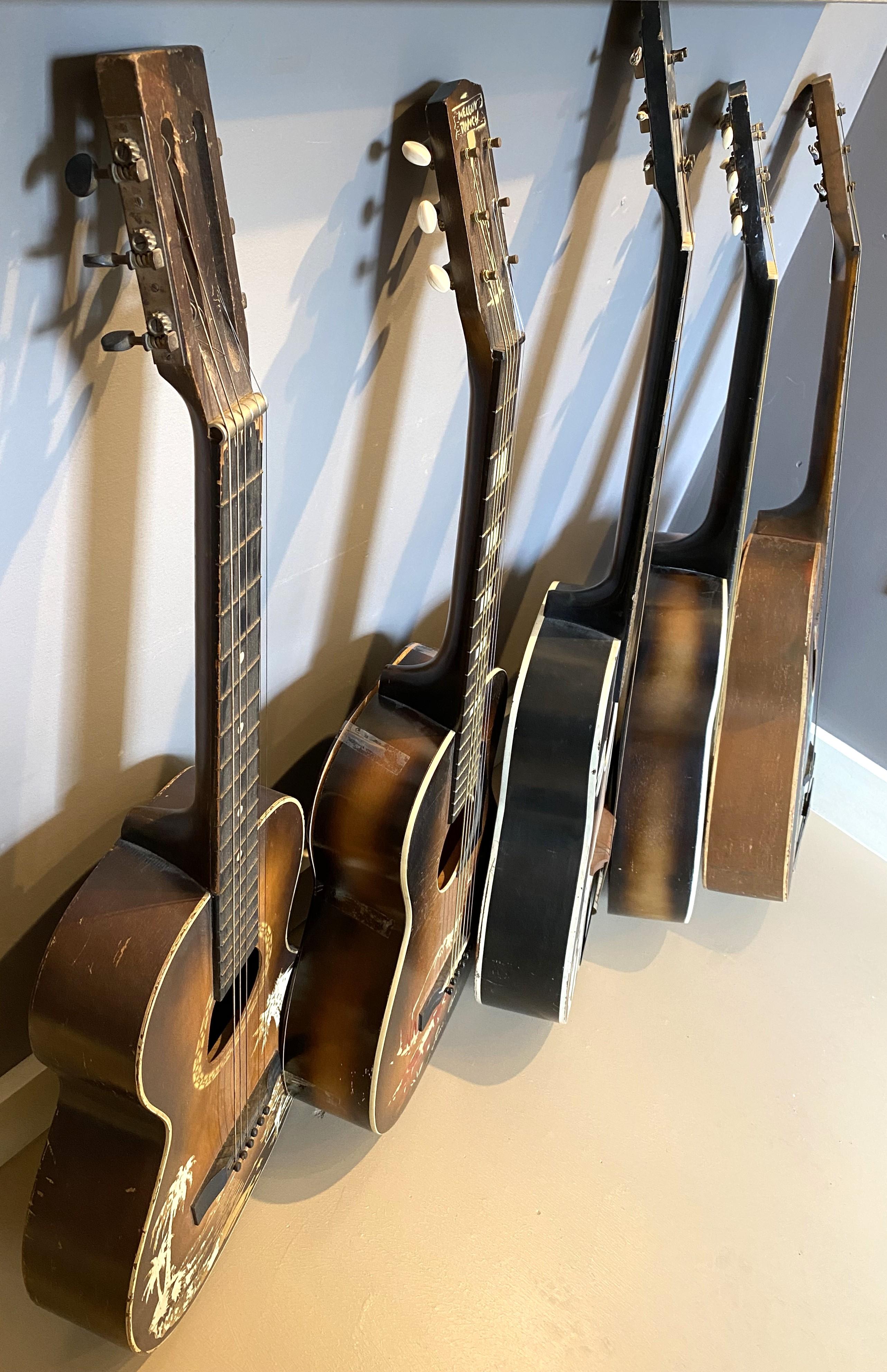 A fun collection of mid century acoustic cowboy guitars, including two Gene Autry Melody Ranch models, circa 1940’s, some unsigned, and one hand painted with “The Plainsman” on the peg head. Each guitar shows some cowboy stenciled scene or island