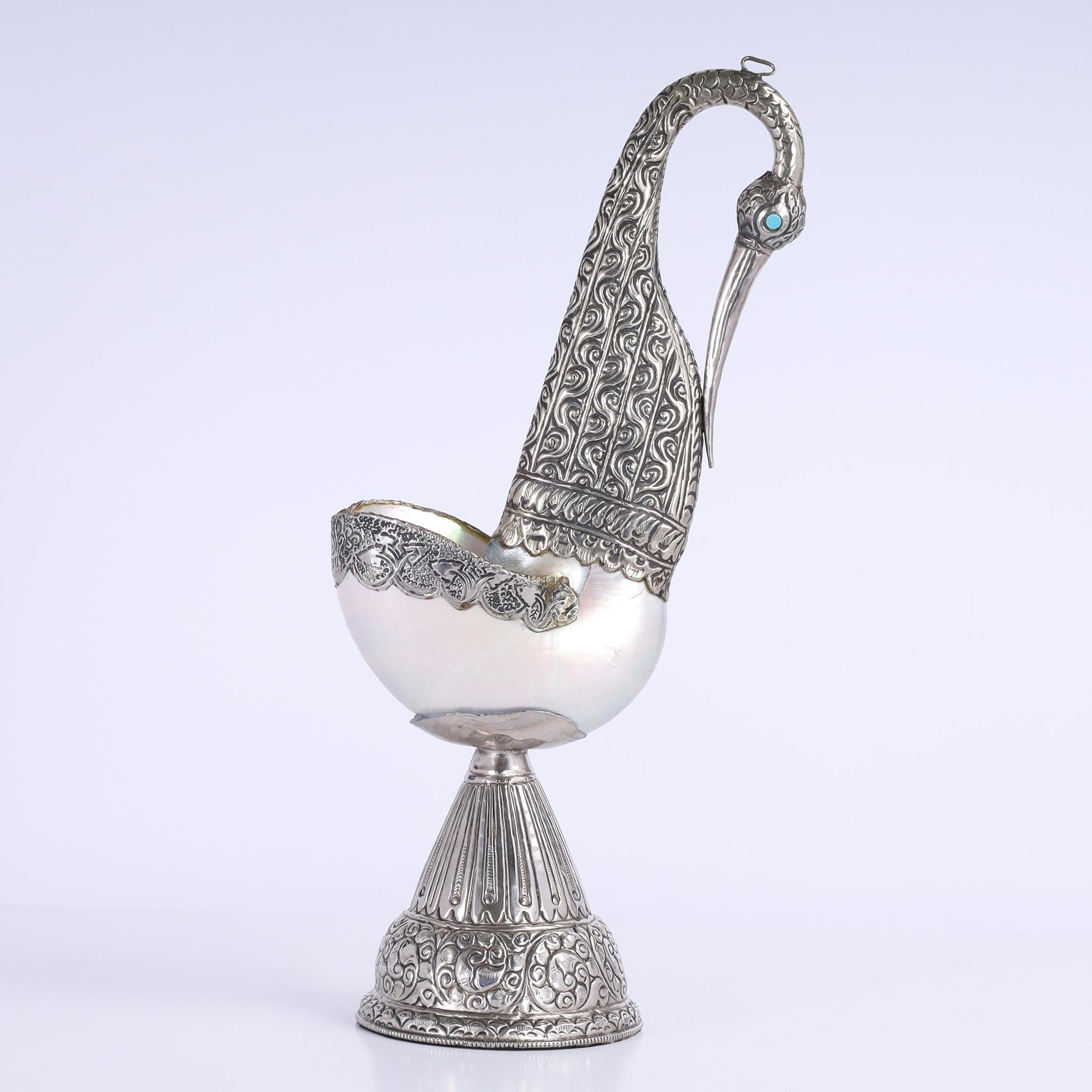 Soberbio grupo de cuatro esculturas u objetos de arte de cisne angloindio elaborados artesanalmente con conchas de mar o nautilos y bases de metal martillado cuellos y cabezas con ojos de piedra.

La más grande H: 15 W: 7.5 D: 4.5 $1,750.00
Mediana: