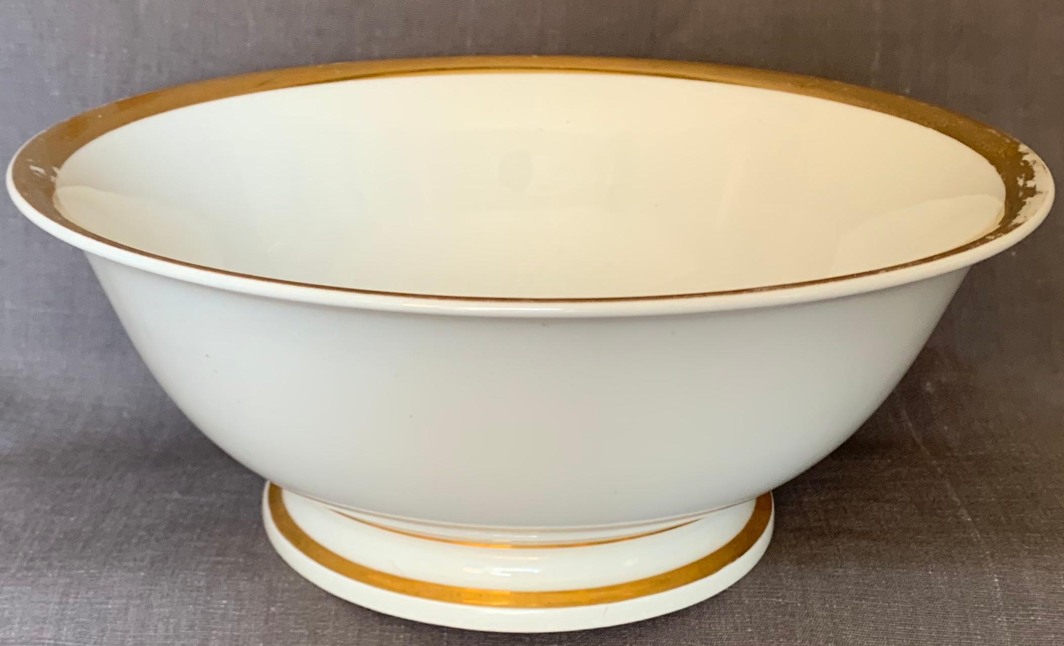 Group of gilt white Paris porcelain. French Empire period large white footed serving bowl, three plates and footed cachepot/small serving bowl with gilt banding and markings for 