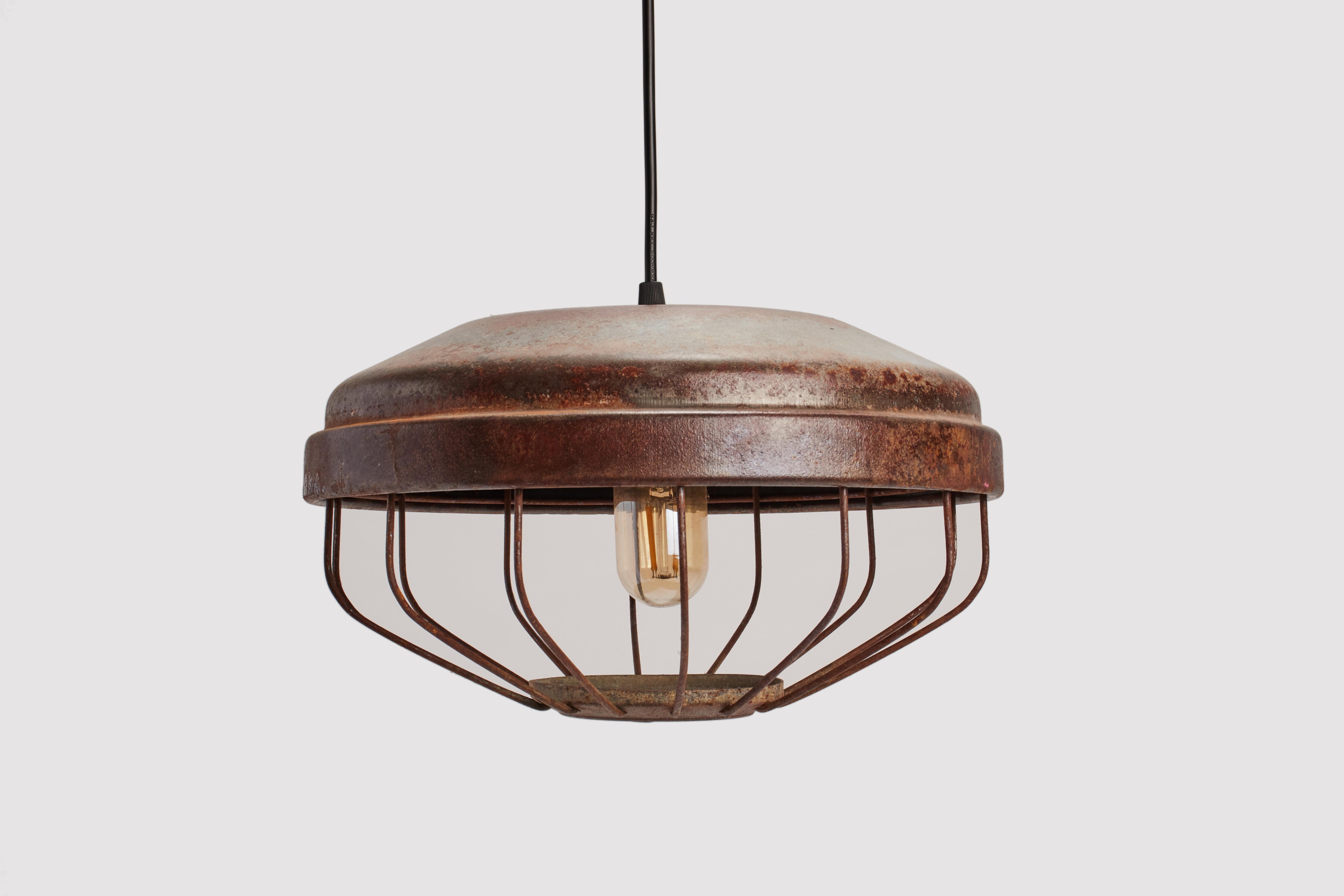 Lampes industrielles suspendues en métal émaillé, de couleur vert cuivre, avec cage en fer, pour protéger l'ampoule. USA vers 1920.  