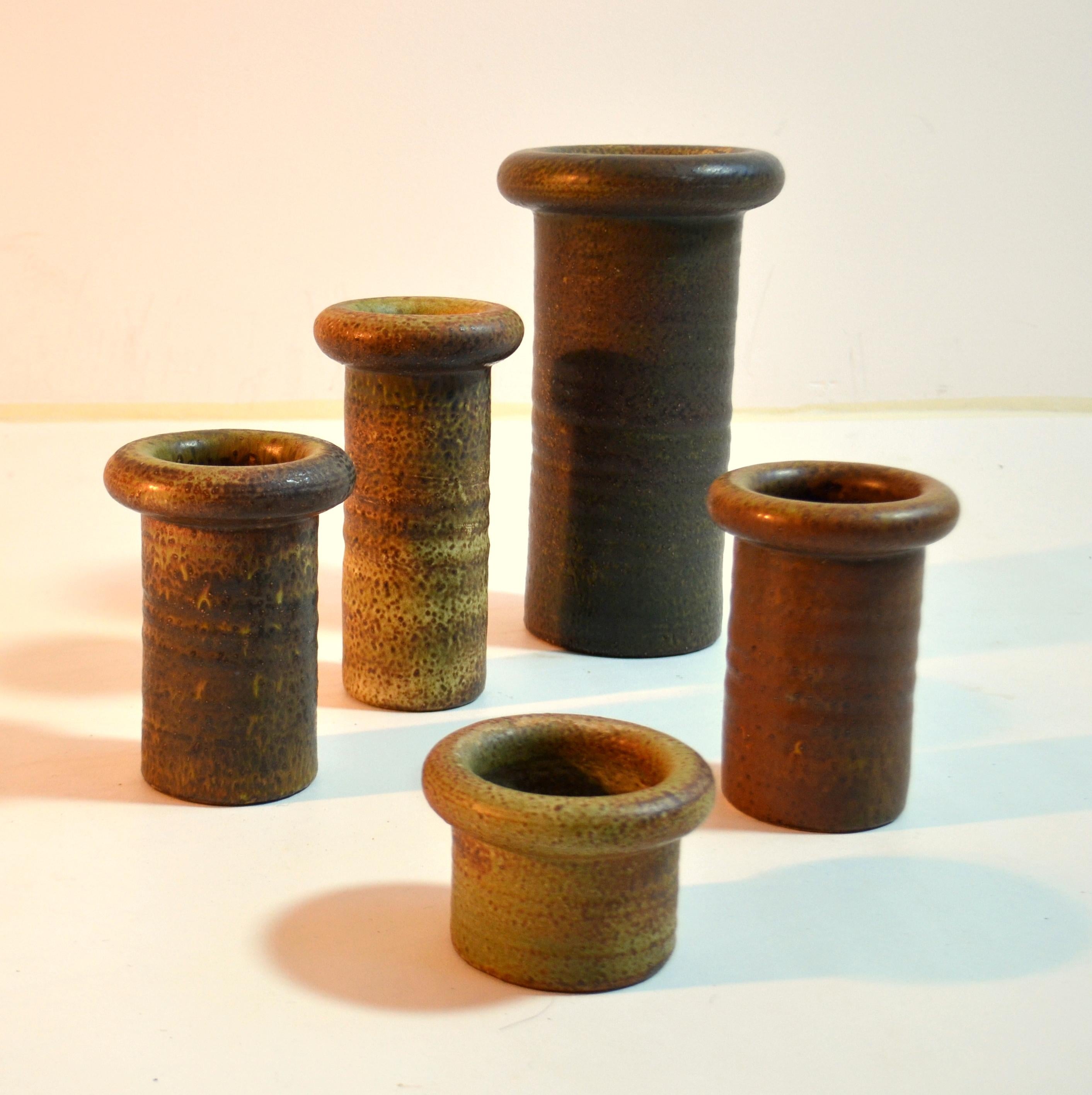 A collection of five rolled neck cylinder vases in differing heights with earth tone and glazes in muted tones, all created on the turning wheel by highly technical skilled master potter Piet Knepper, the Dutch Mobach ceramist in the 1960's. All the