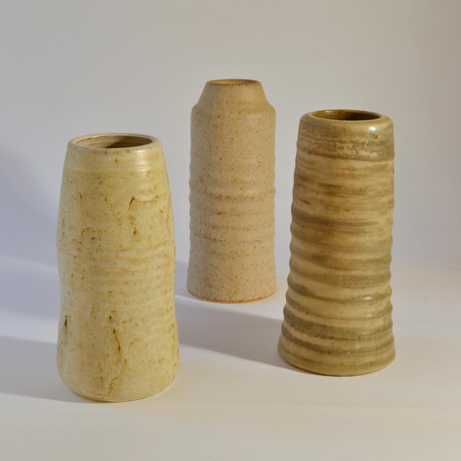 Three-cylinder Studio Pottery vases in white tones are very sculptural with a natural rough character created on the turning wheel by highly technical skilled Dutch ceramist in the 1960s. The glazes made of natural resources are highly influenced by