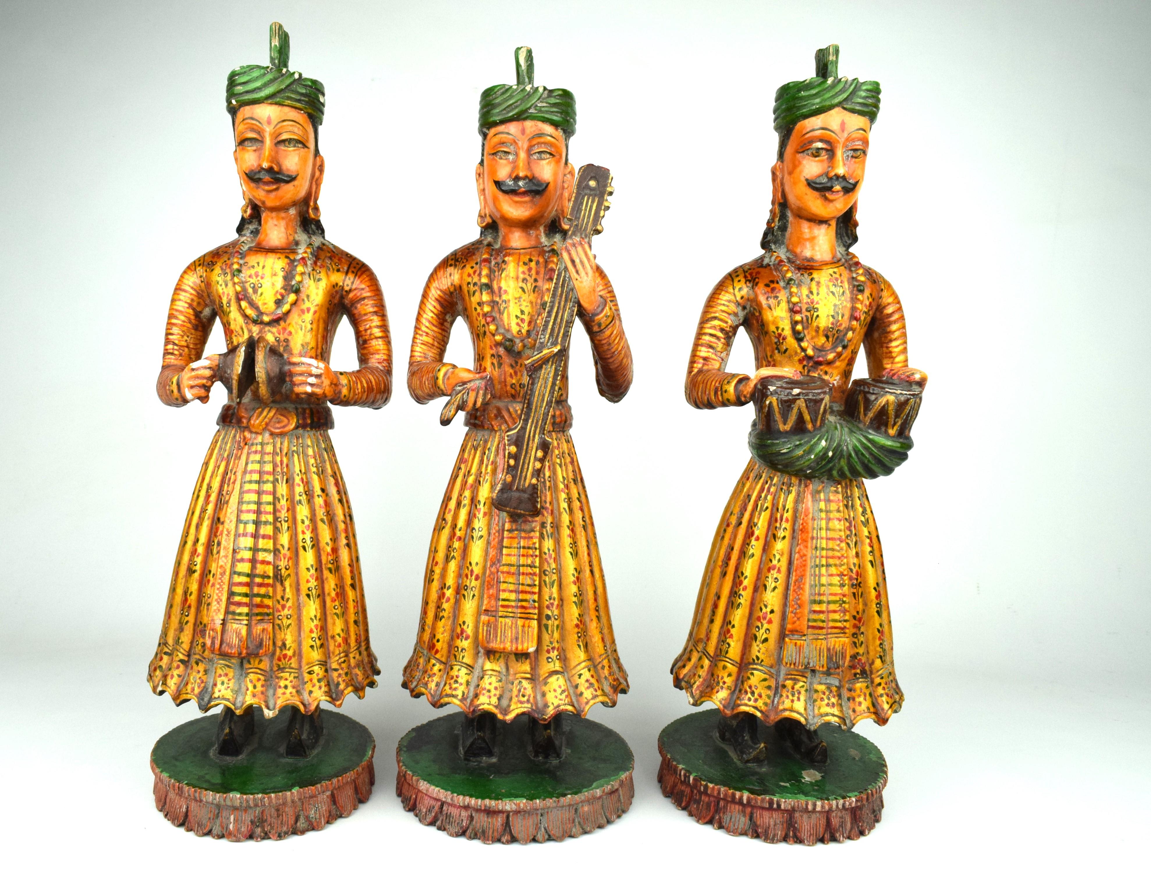 Ce groupe de trois figurines de musiciens en bois du Rajasthan est un exemple étonnant de l'artisanat traditionnel indien. Ces sculptures aux détails complexes et magnifiquement travaillés sont taillées à la main dans du bois, mettant en valeur les