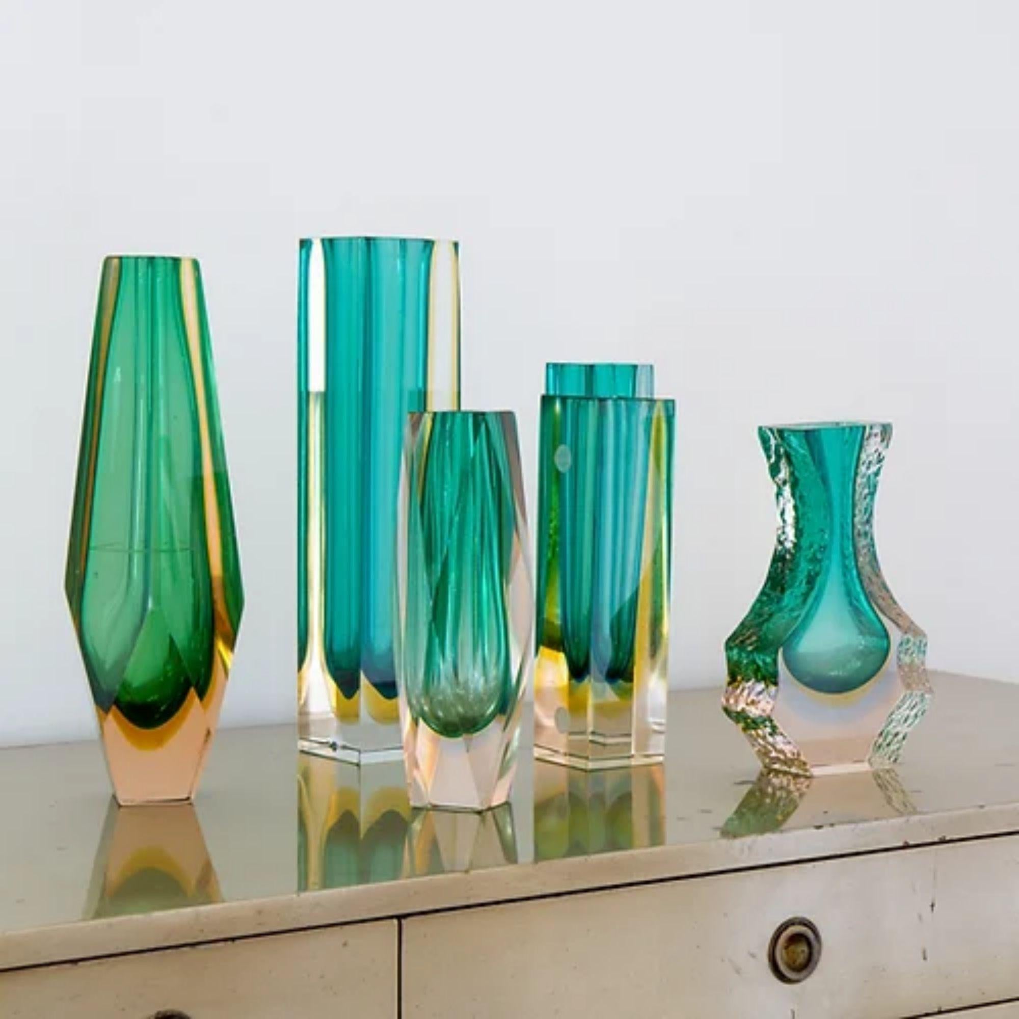 A group of six green Murano glass vases comprising of:

An Unusual Faceted Sommerso Glass Vase with a Green and Amber Centre Cased in Tinted Peach Glass
29cms high x 8cms across

A Facet Cut Murano Sommerso Glass Vase with a Pale Green, Gold and