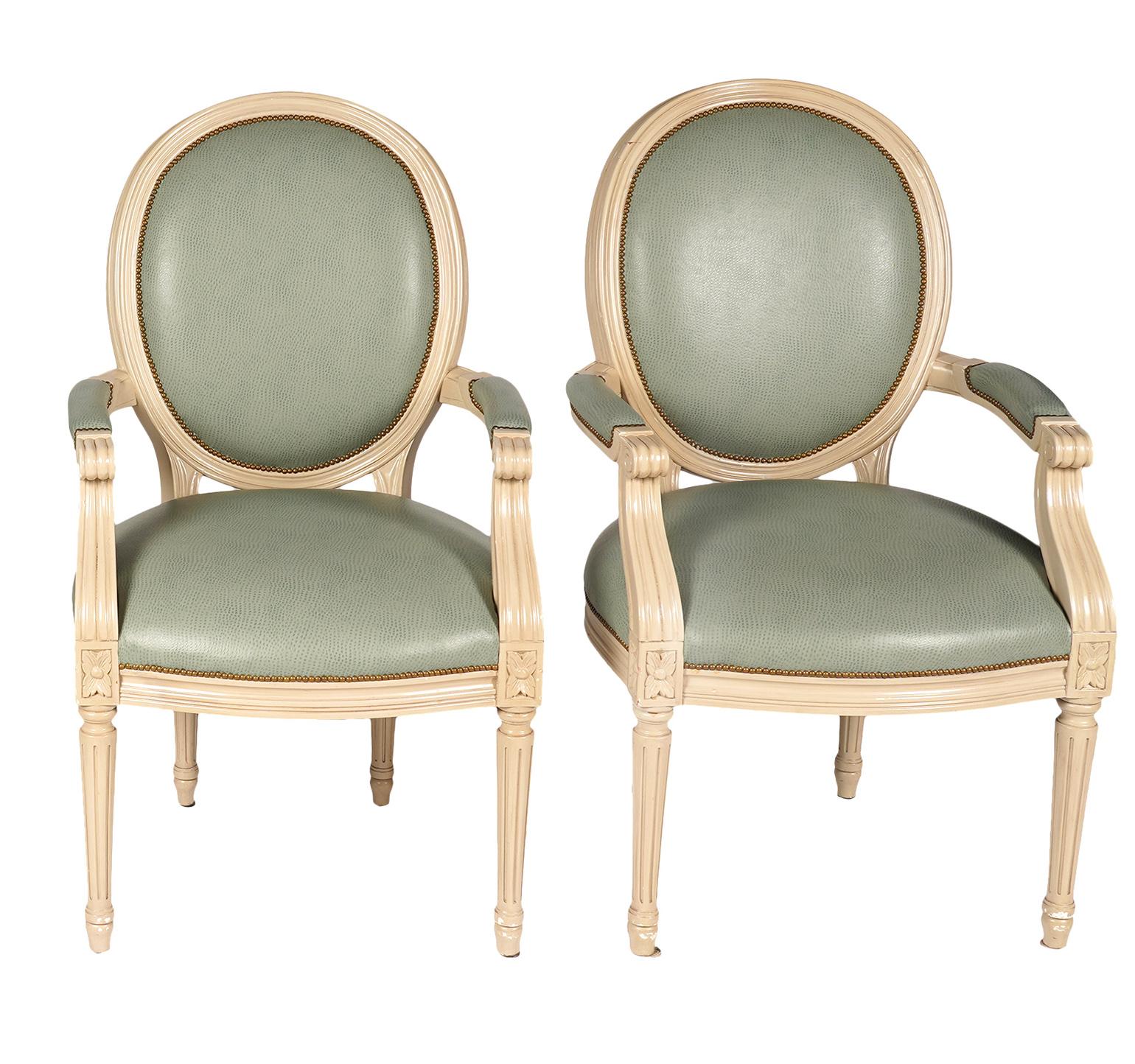 These distinguished chairs are fashioned in the Louis XVI style with oval back rests and round fluted legs. They are painted in a attractive Ivory color and covered with a stain resistant synthetic material.