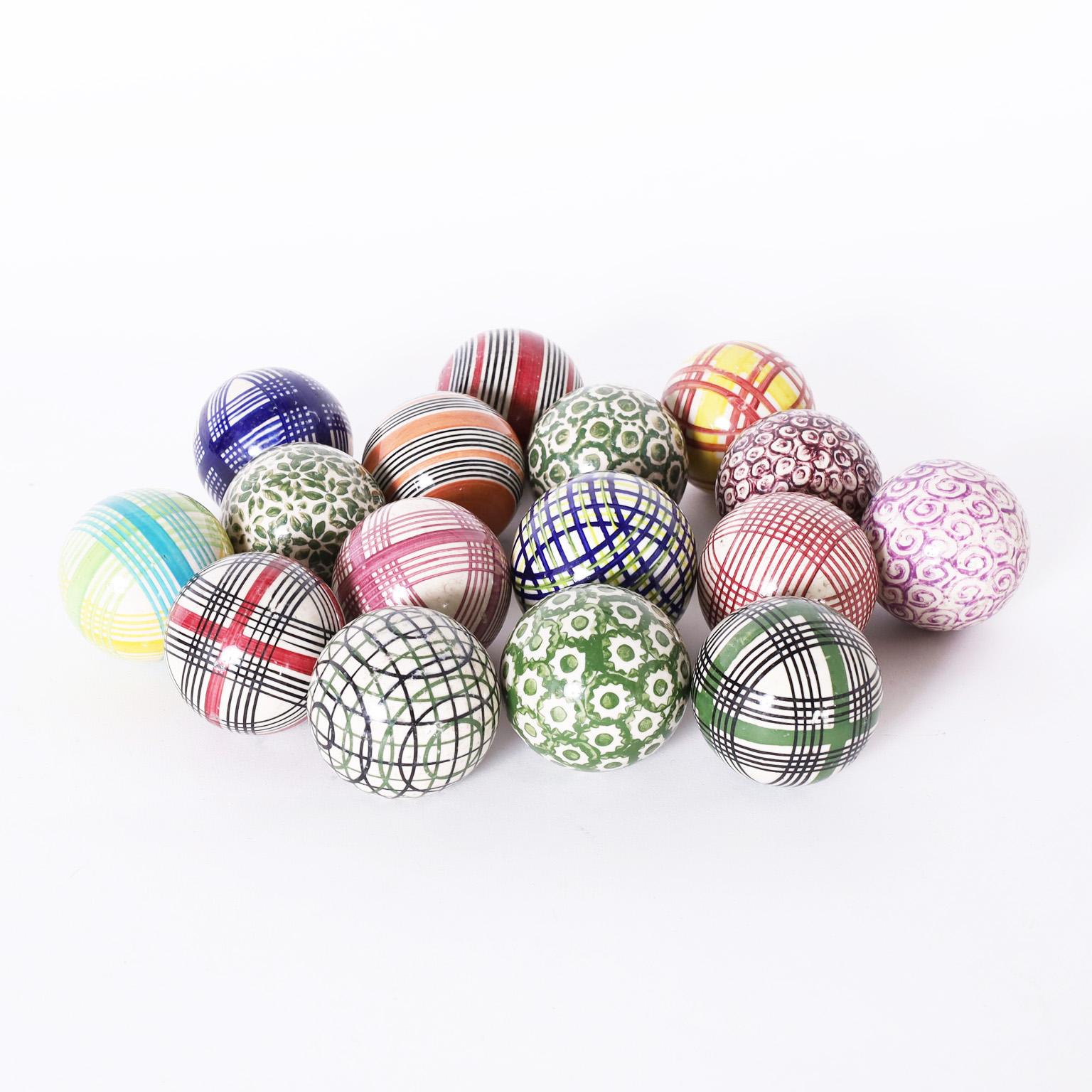Here is a collection of sixteen English carpet balls crafted in stoneware. Hand decorated and glazed in a variety of colors and designs.