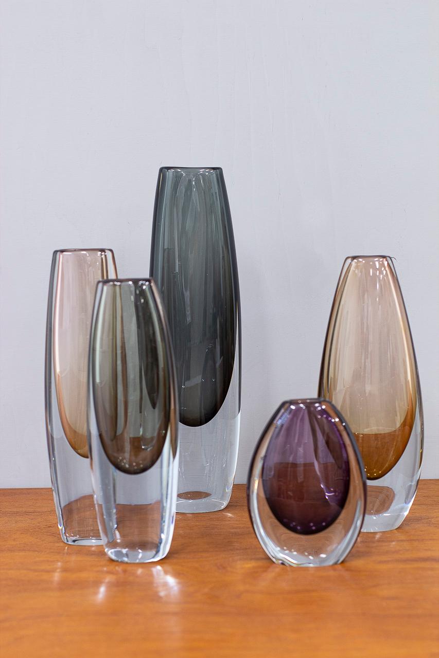 Group of 5 “sommerso” type vases. Designed by Gunnar Nylund and Asta Strömberg. Manufactured by Strömbergshyttan in Sweden during the 1950s. Coloured glass cased in clear glass technique. Three of the vases are signed (engraved on the bottom).
The