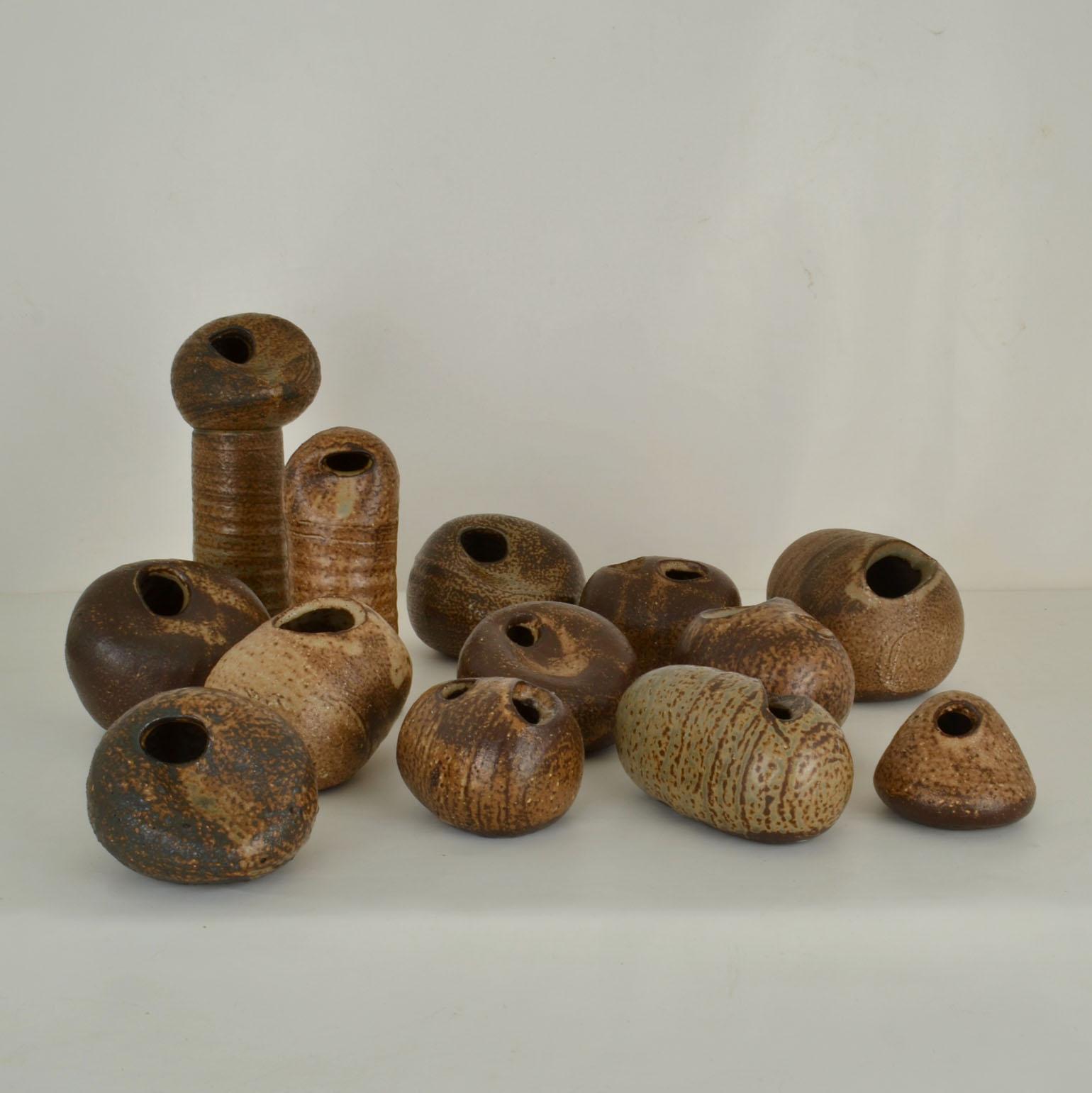 Set di tredici vasi di ciottoli in Studio Pottery, smaltati nei toni naturali della terra e in varie altezze dal ceramista olandese Jaan Mobach. I vasi sono in parte torniti e in parte formati a mano in forma di ciottoli con aperture simmetriche ad