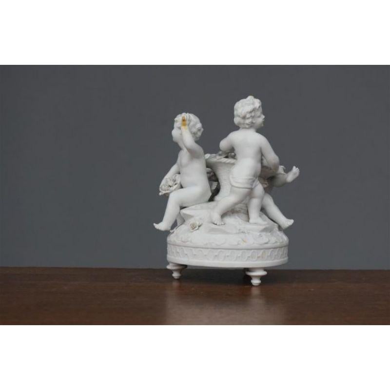 Porcelain Group of Three Cherubs Around a Biscuit Basket, 1900 Period For Sale