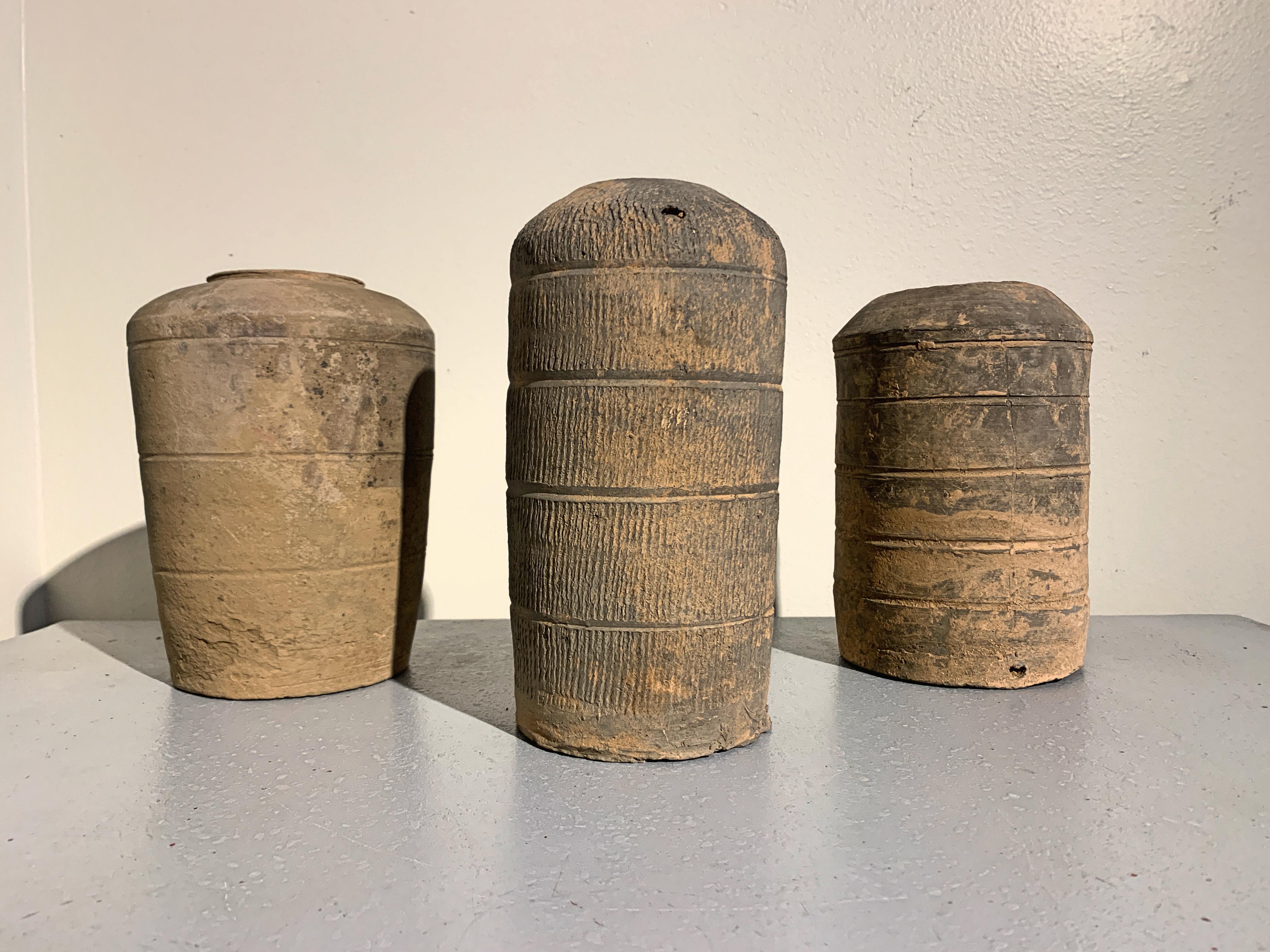 An attractive group of three high fired gray pottery models of granaries, Han dynasty (206 BC-220 AD) style, and most likely of the period, China.

The granary models of varying cylindrical form, with slightly domed tops and circular openings. The