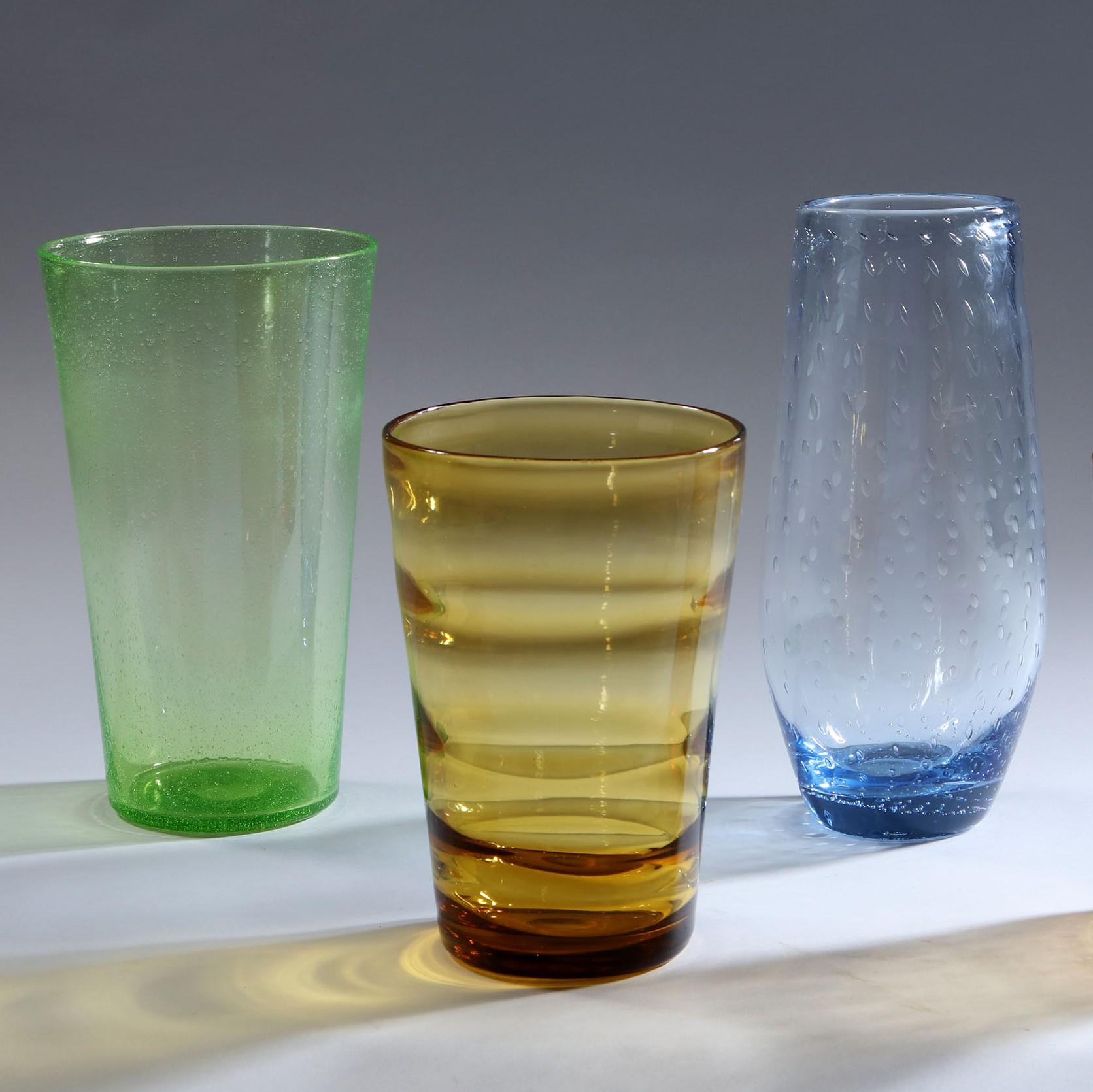 A group of three Whitefriars glass vases of differing colors, heights and decorations. Green, blue and gold.