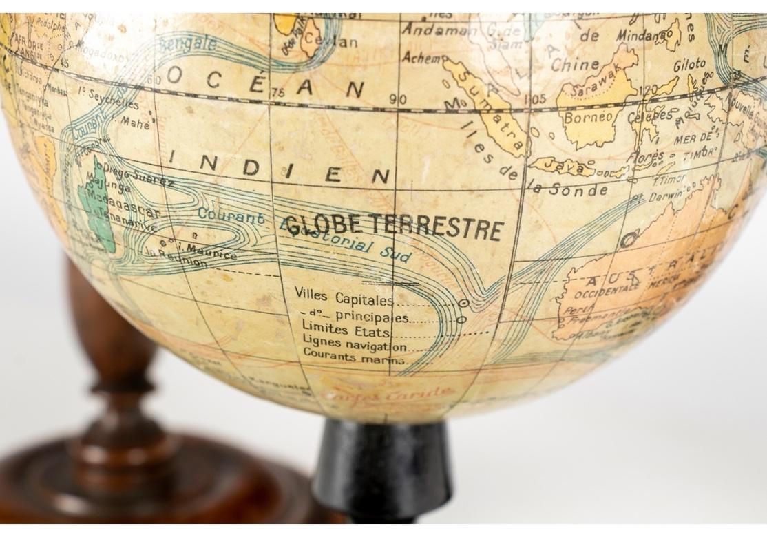 A very fine group of World Globes on pedestal mounts. All printed paper globes. A large Globe Metrique by G. Thomas, Paris. Mounted on metal on an ebonized wood base. Measures: Height 19