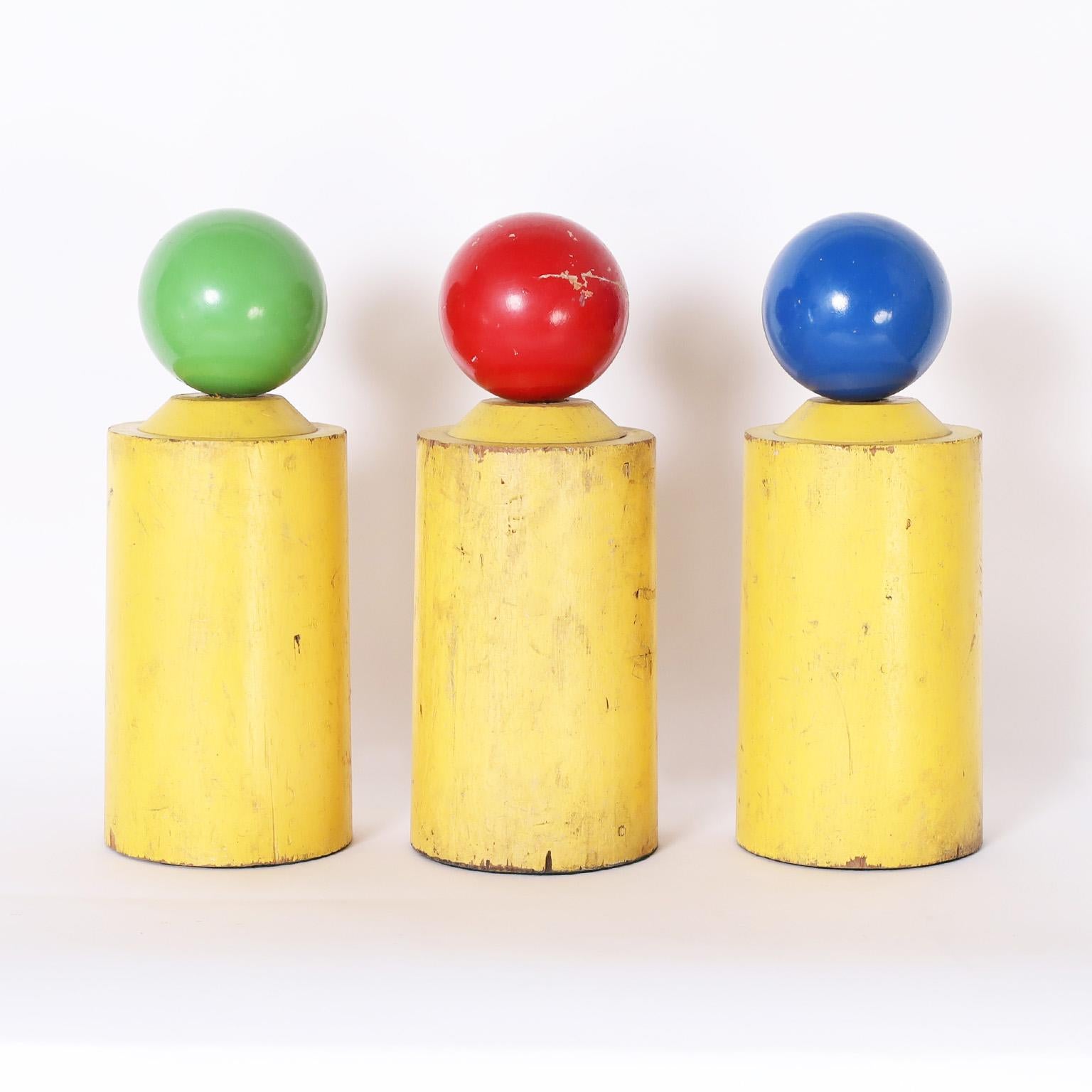 Intriguing group of three vintage decorative markers crafted in wood and painted with primary colors, now distressed.