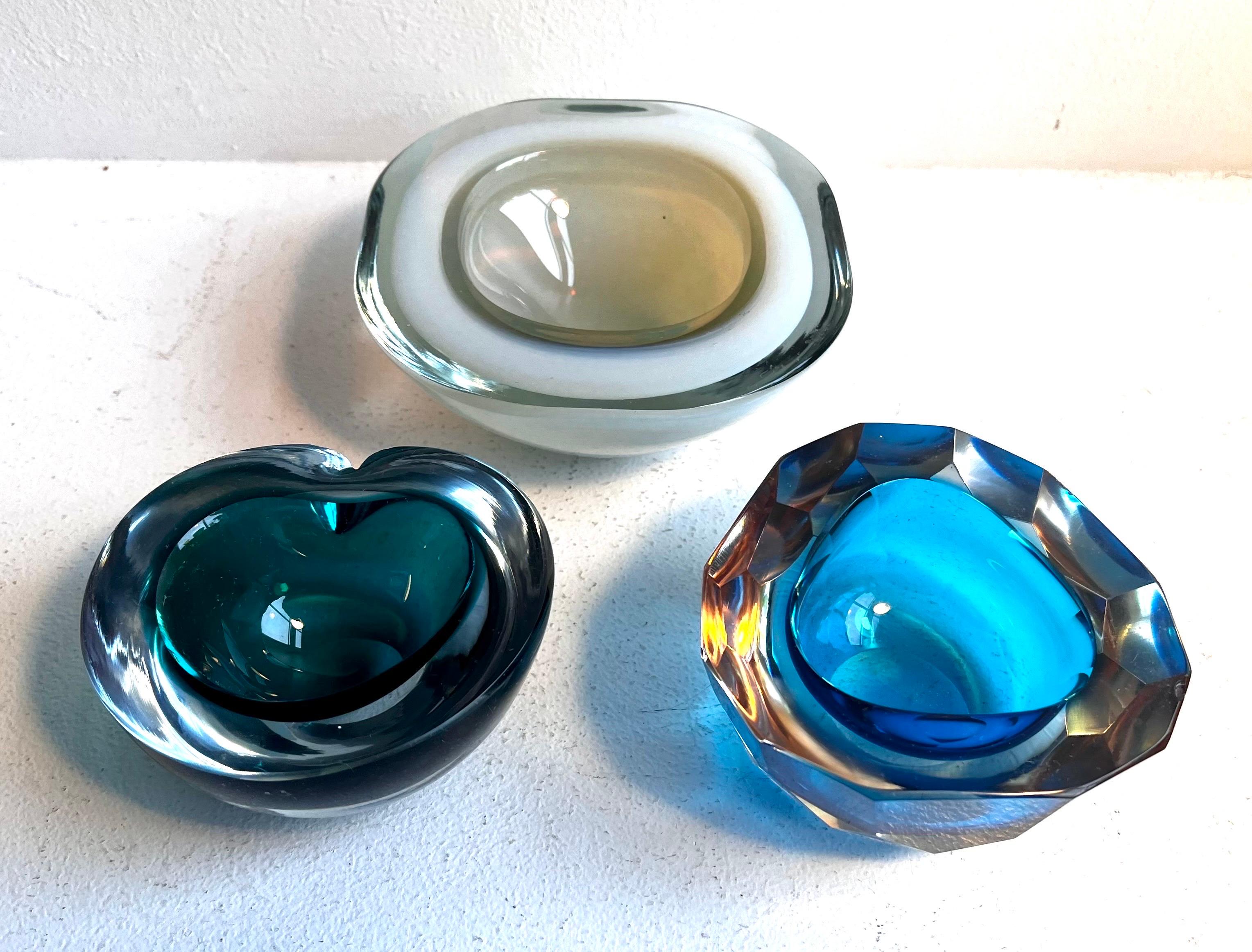 Gruppe von drei kleinen Gefäßen aus dickem Glas
