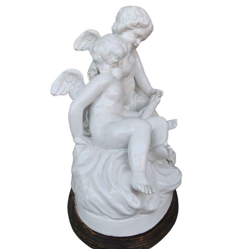 Group of two cherubs around a late 19th century porcelain basket on its wooden base measuring 42 cm by 44 cm by 25 cm deep. Very good quality of sculpture. maybe a little re-gluing on one foot (we don't know if it's not more of a cooking