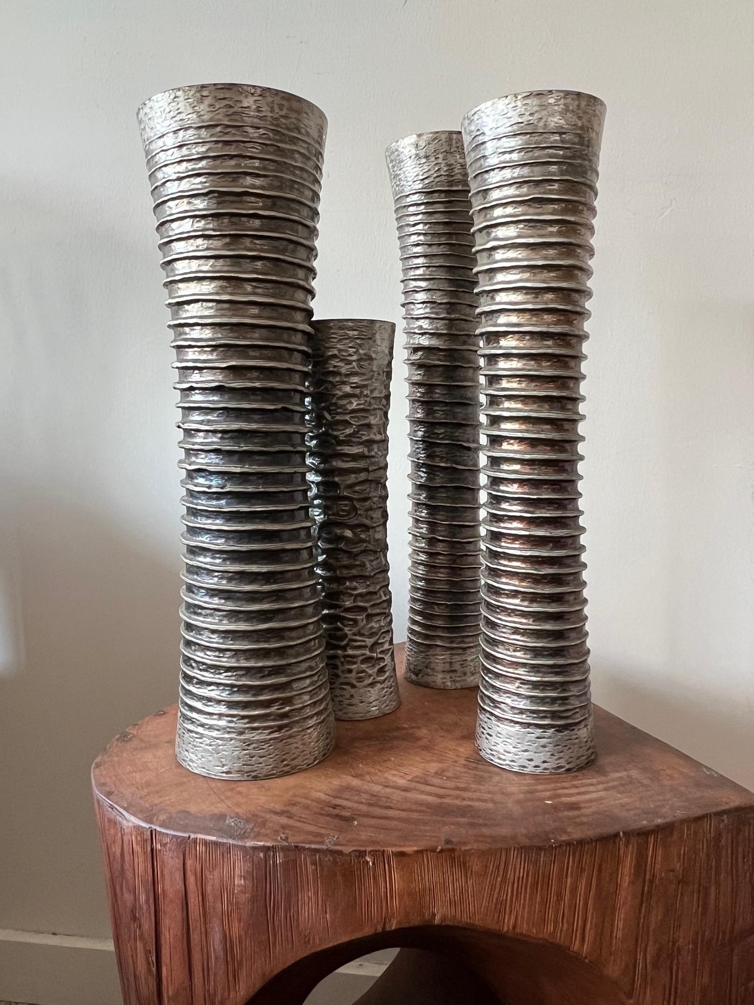 A group of four handmade vases in silvered metal by Atelier des Orfevres, Italy. A maker of jewelry and decorative objects, some pieces designed by Ken Scott.