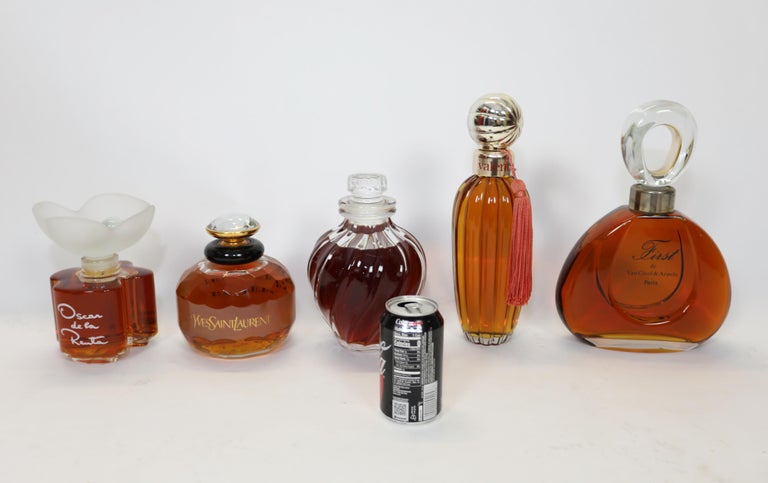 A group of 5 oversized perfume bottles.
These were purchased c .1975.
Can not guarantee perfume is correct
See soda can for sense of scale.

